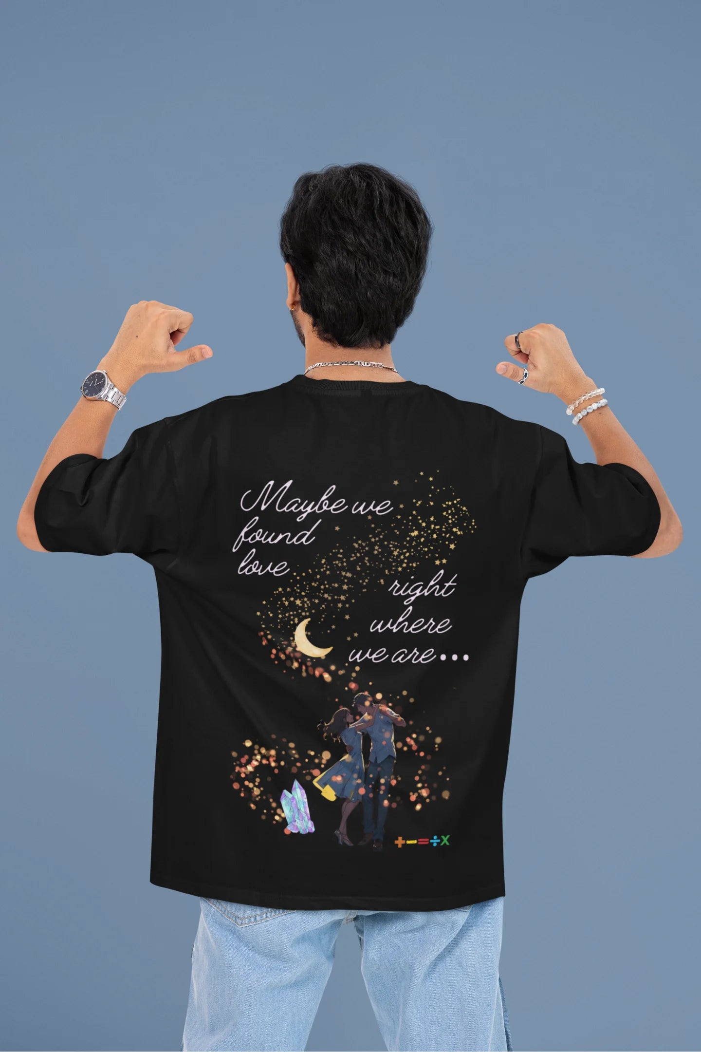 Back view of a male model wearing a black oversized t-shirt featuring a couple dancing in the moonlight, inspired by Ed Sheeran's themes of love.