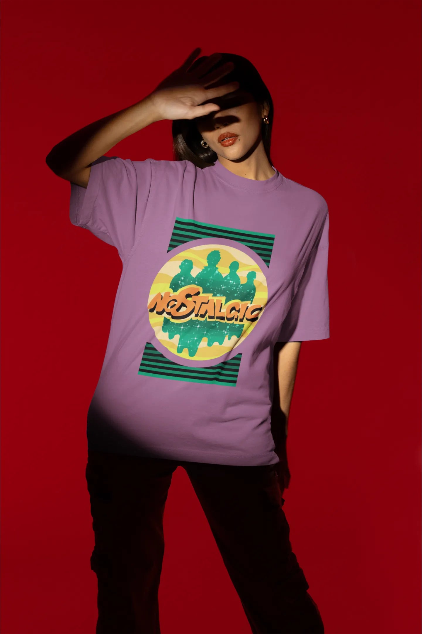 Second view of a female model wearing an oversized dirty purple t-shirt with a shadow silhouette of the Coldplay band members and the word "Nostalgic" printed on it.