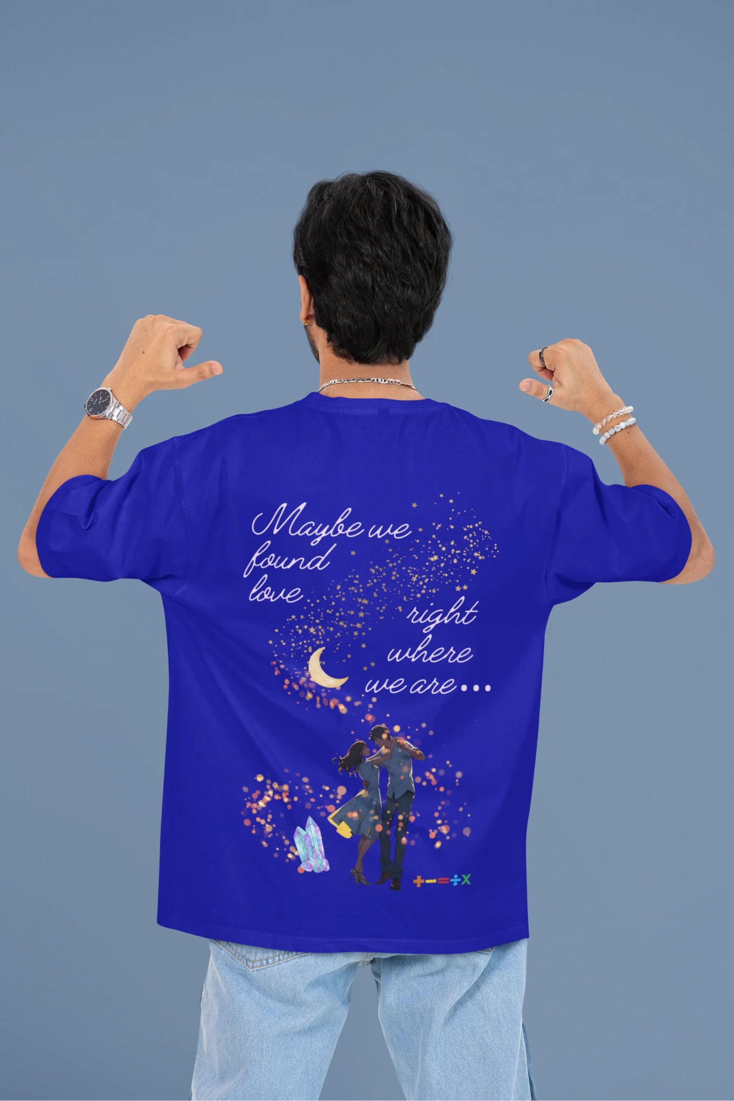 Back view of a male model wearing a royal blue oversized t-shirt featuring a couple dancing in the moonlight, inspired by Ed Sheeran's themes of love.