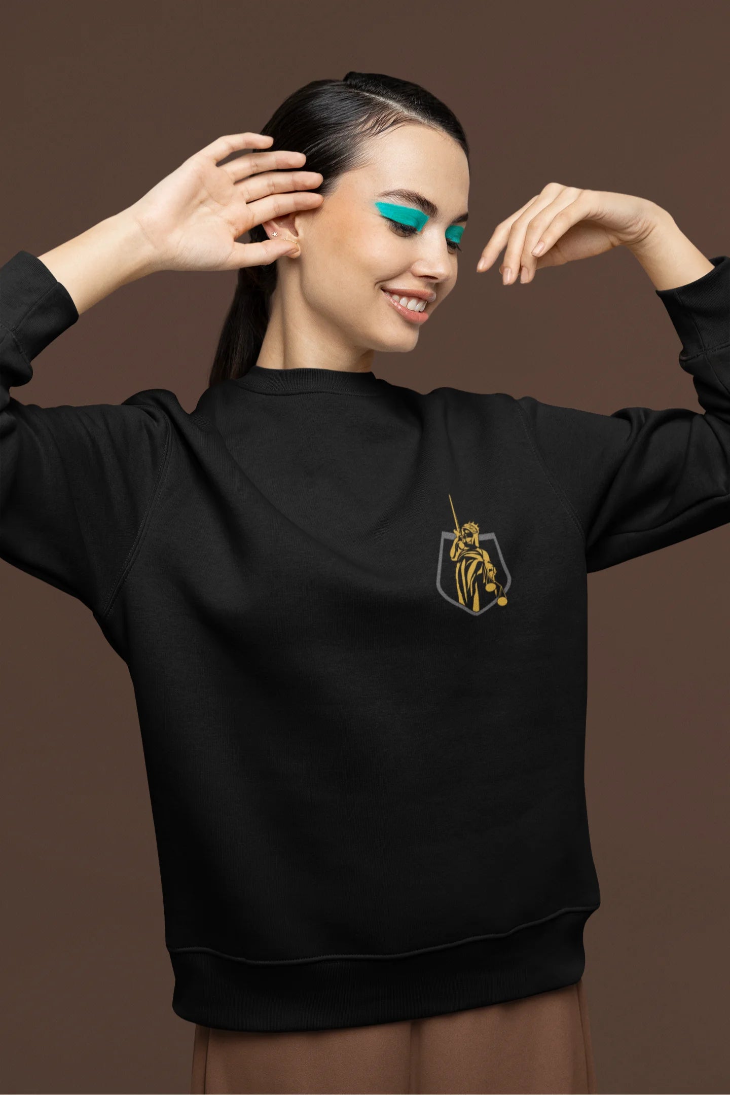 Fourth front view of a female model wearing a black sweatshirt with a brutalist Lady Justice statue design.
