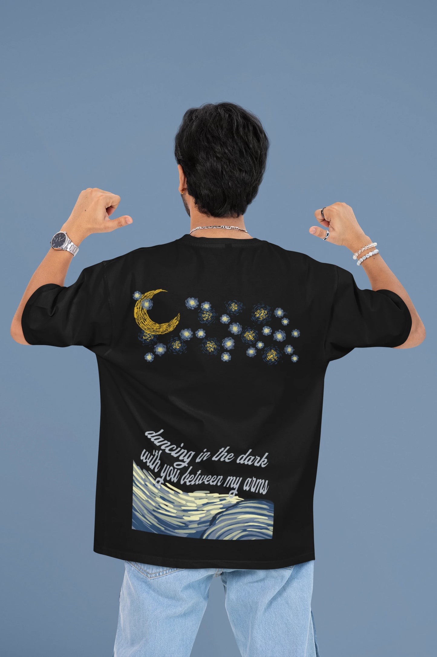 Back view of a male model wearing a black oversized t-shirt featuring lyrics from Ed Sheeran's song "Perfect" against a night sky design.