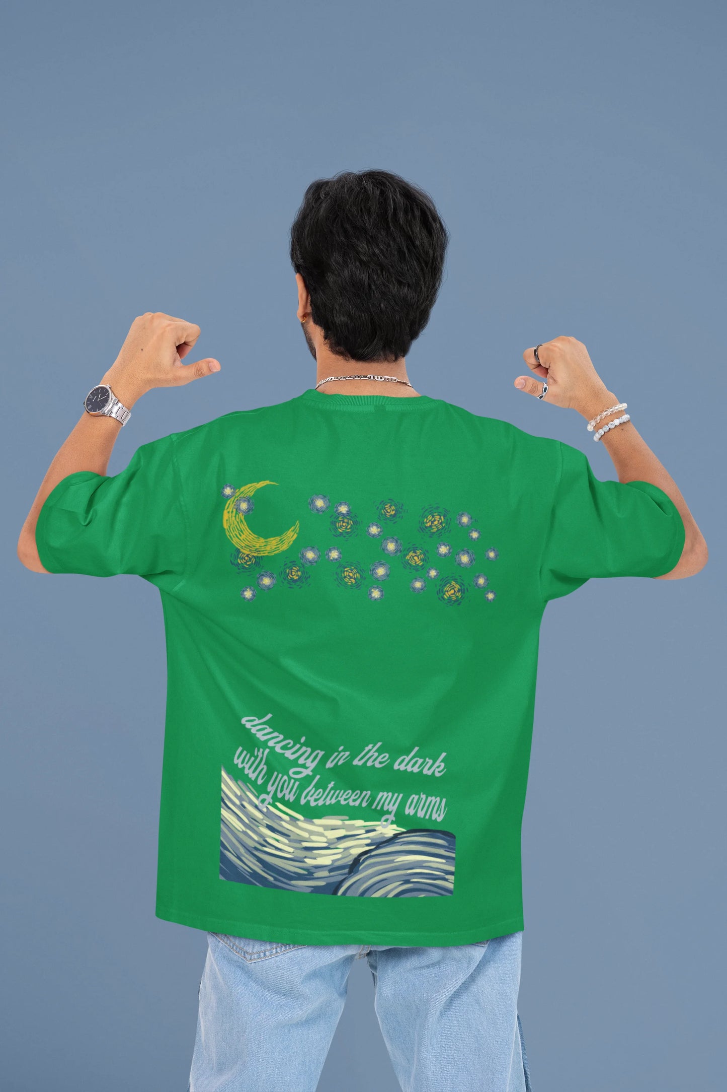 Back view of a male model wearing a forest green oversized t-shirt featuring lyrics from Ed Sheeran's song "Perfect" against a night sky design.