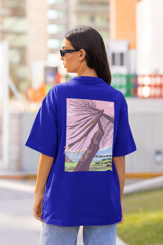 Back view of model wearing blue oversized Taylor Swift Willow t-shirt featuring designs inspired by her album Evermore (Taylor's Version)