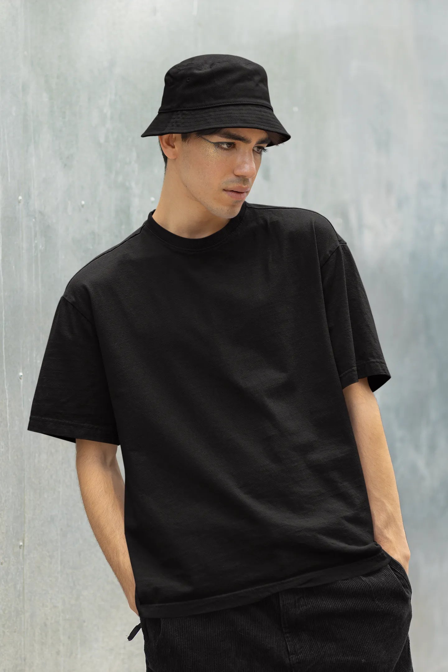 Front view of a male model wearing a black oversized t-shirt with a punk techno angel design, perfect for rave and party wear.