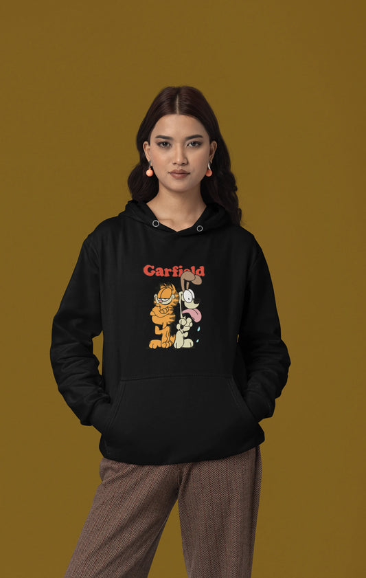Second front view of a female model wearing a black hoodie with a Garfield illustration showing the cat standing back to back with Odie, surrounded by a playful cartoon border.