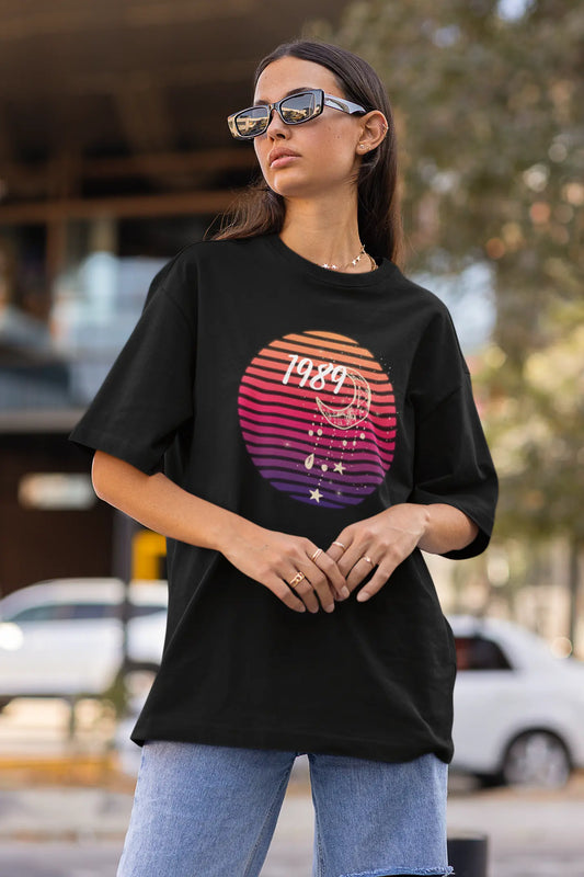 Side view of woman wearing black coloured Oversize T-shirt featuring Taylor Swift 1989 design, Taylor's Version, and Eras Tour Merch