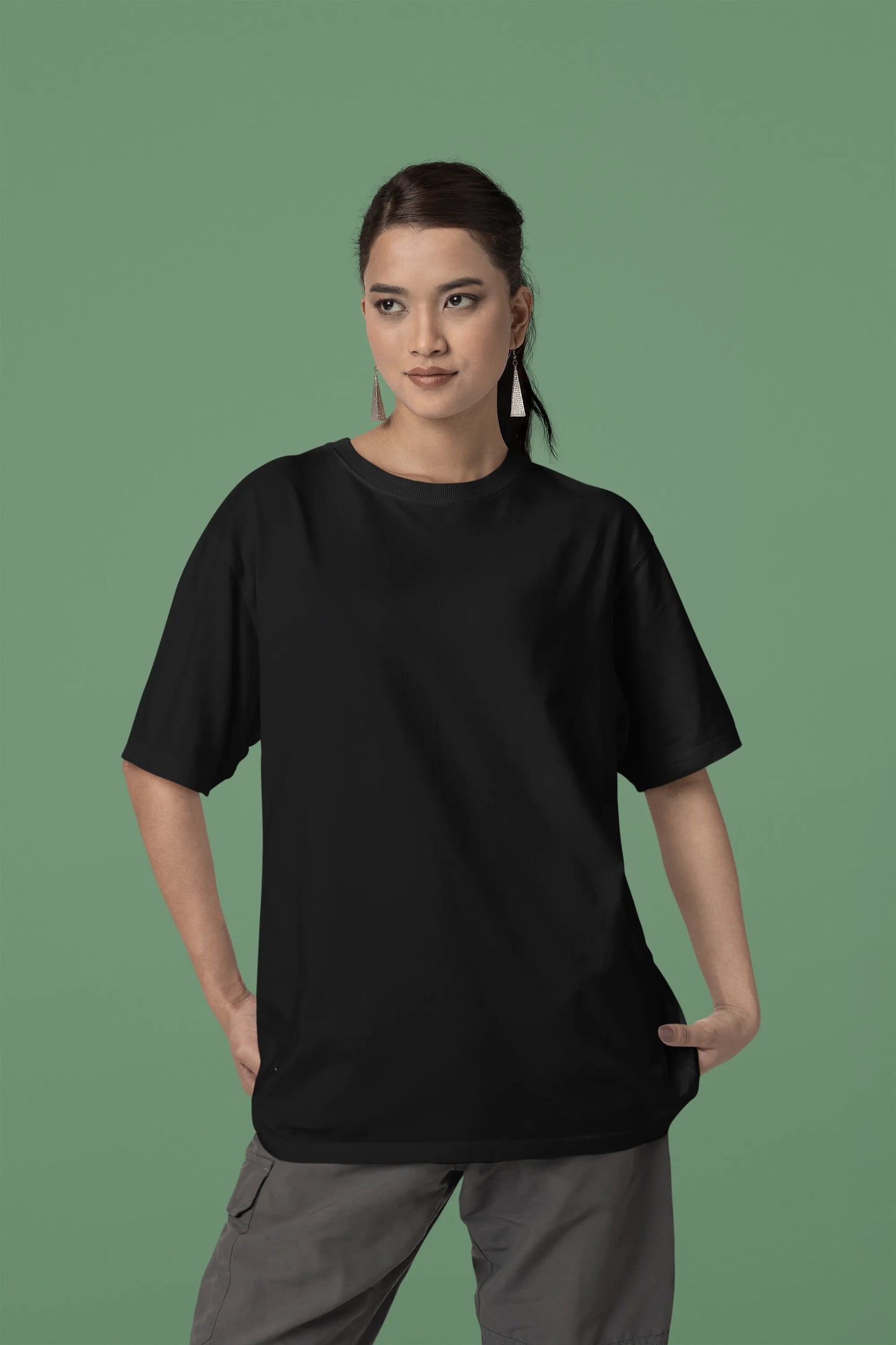 Front view of a female model wearing a black oversized t-shirt with a metal flower design and "Be a Voice, Not an Echo" slogan.