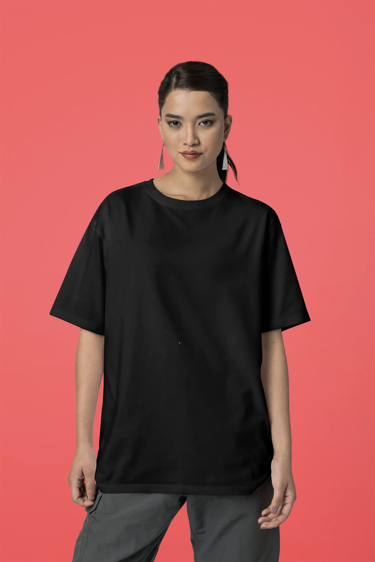 Front view of a female model wearing a black oversized t-shirt with a punk techno angel design, perfect for rave and party wear.