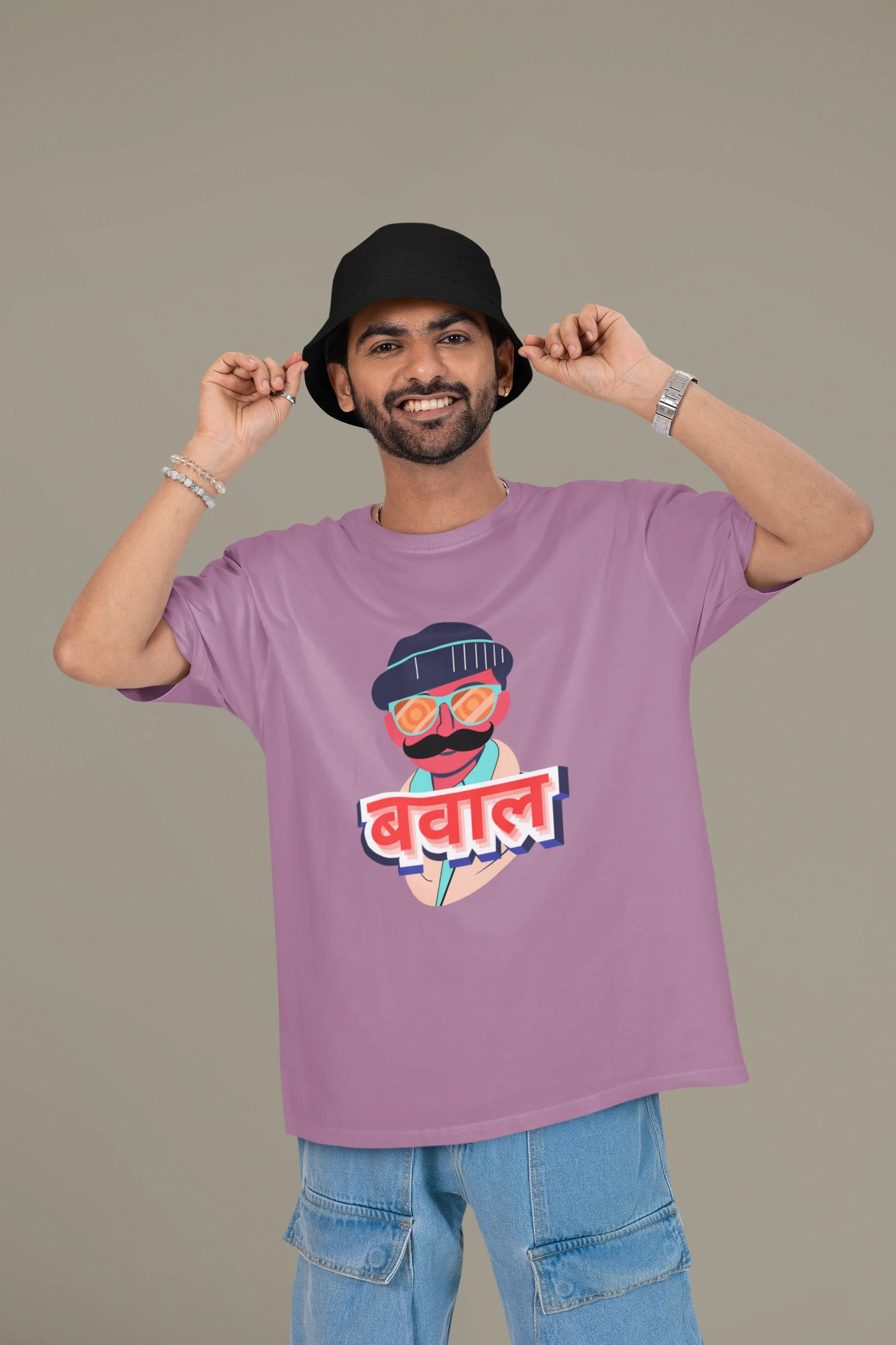 2nd front view of a male model wearing a dirty purple oversized t-shirt with "Bawaal" in a stylish Hindi.
