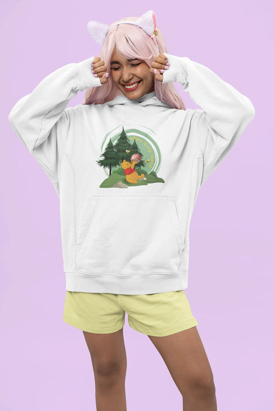 Front view of a female model wearing a off-white hoodie with a Winnie the Pooh design, showing the Disney bear eating honey from a jar in a forest.