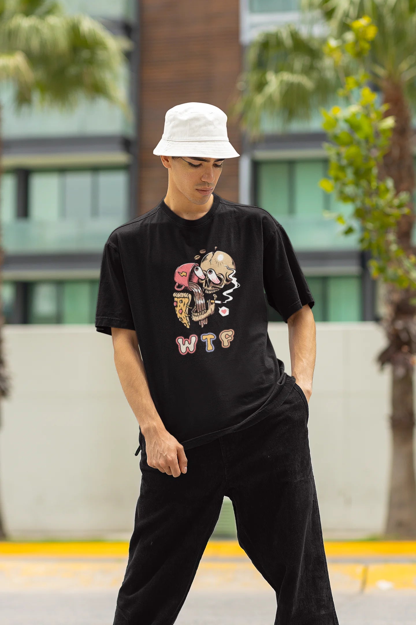 Front view of a male model wearing an black oversized t-shirt featuring a skull enjoying coffee, pizza, and smoking, offering a unique and edgy aesthetic.