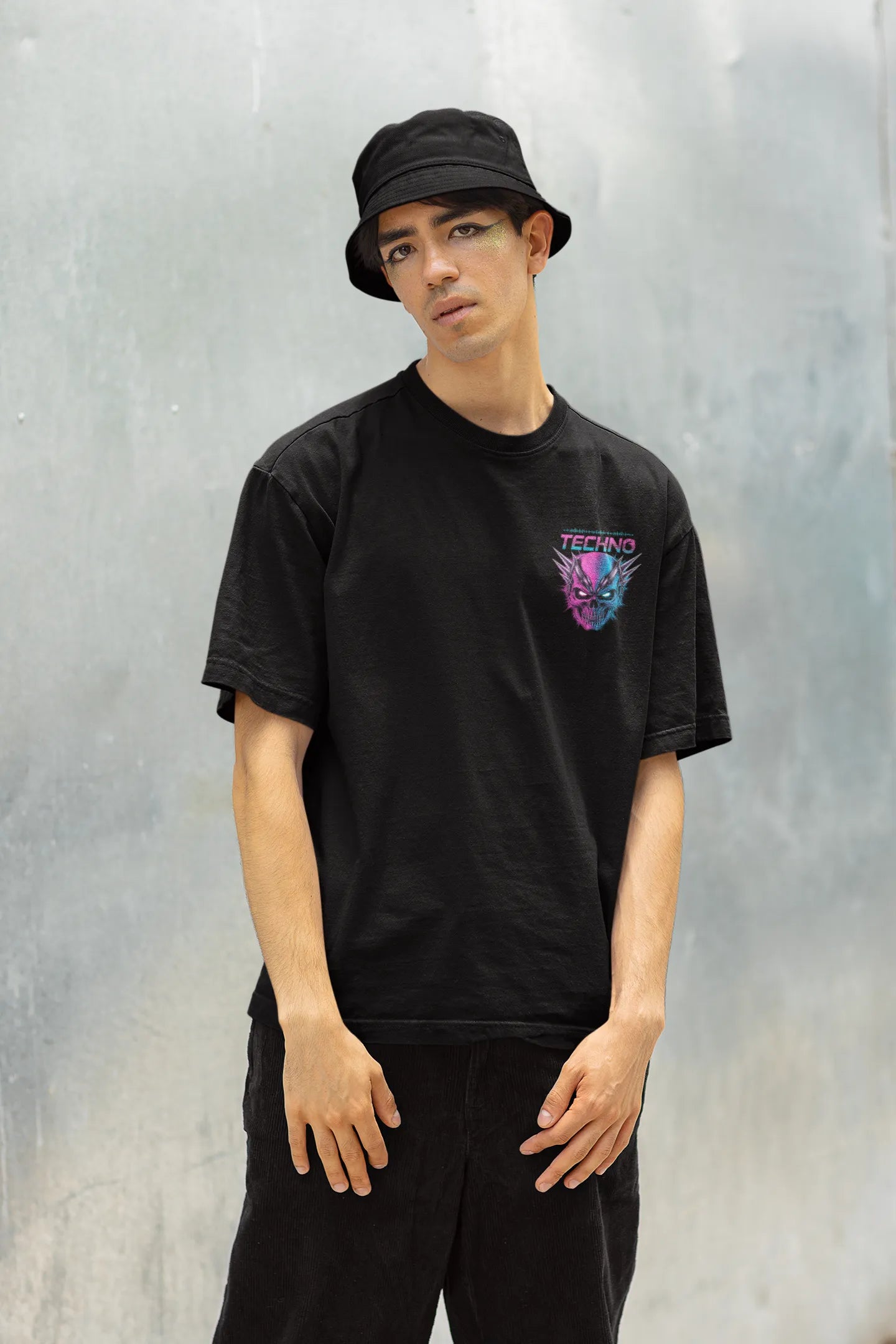 Right side view of a male model wearing an black oversized t-shirt with a stylized Techno Skull design, perfect for rave and party vibes.