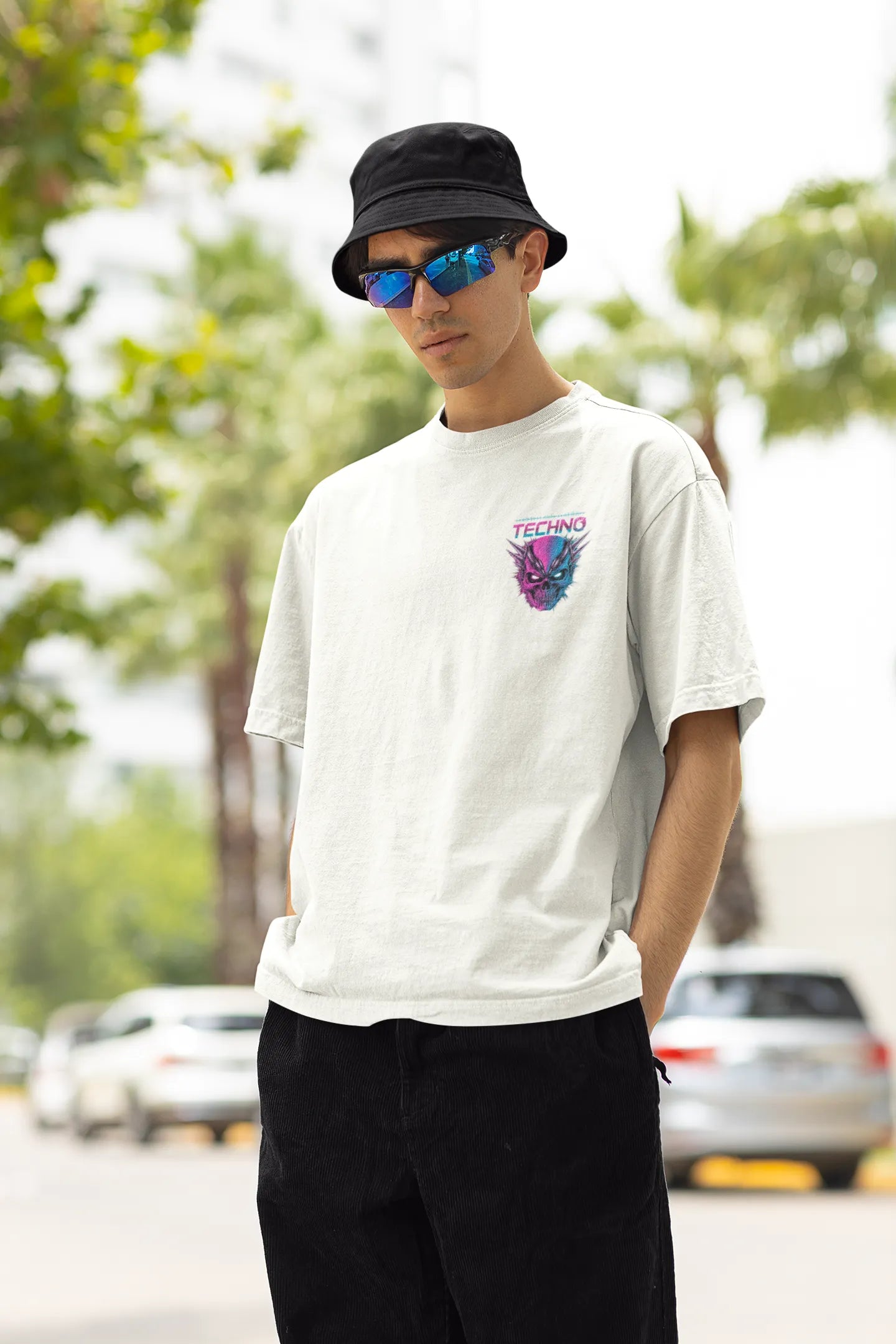 Left side view of a male model wearing an off-white oversized t-shirt with a stylized Techno Skull design, perfect for rave and party vibes.