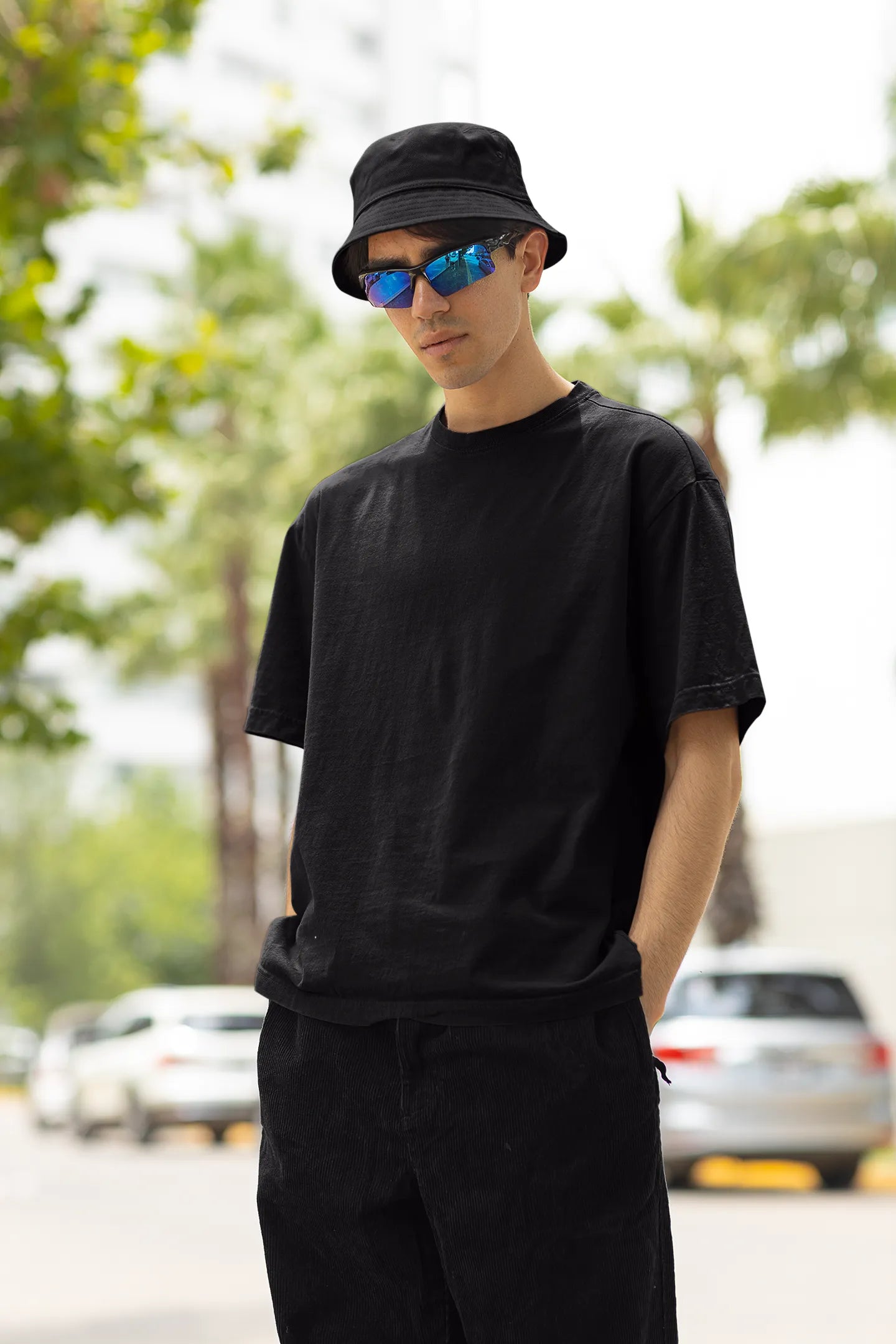 Front view of a male model wearing a black oversized t-shirt with a metal flower design and "Be a Voice, Not an Echo" slogan.