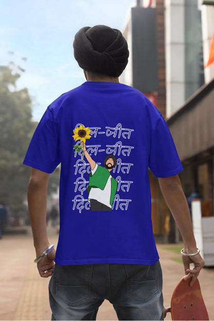Back view of a male model wearing a royal blue oversized t-shirt with a Diljit Dosanjh portrait with the text "Dil Jeet" in the background.
