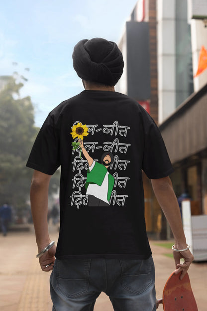 Back view of a male model wearing a black oversized t-shirt with a Diljit Dosanjh portrait with the text "Dil Jeet" in the background.