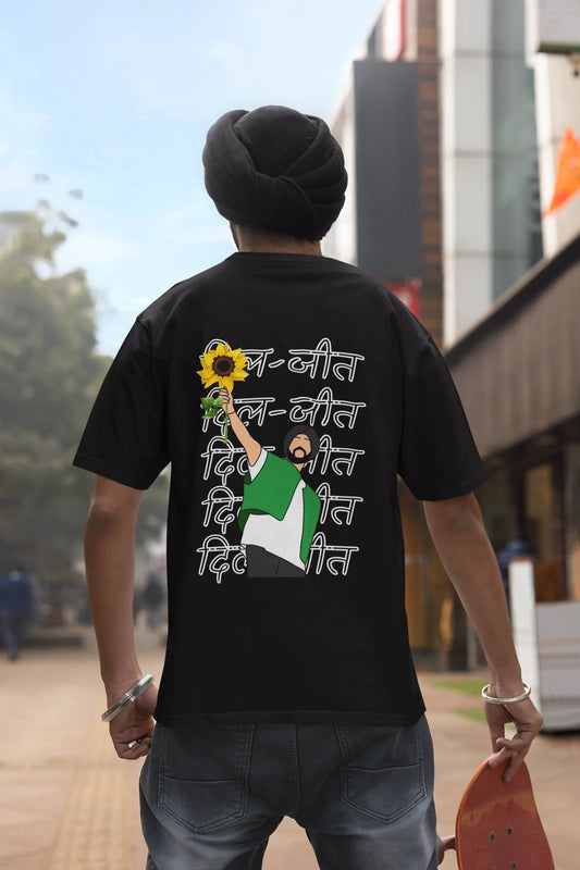 Back view of a male model wearing a black oversized t-shirt with a Diljit Dosanjh portrait with the text "Dil Jeet" in the background.