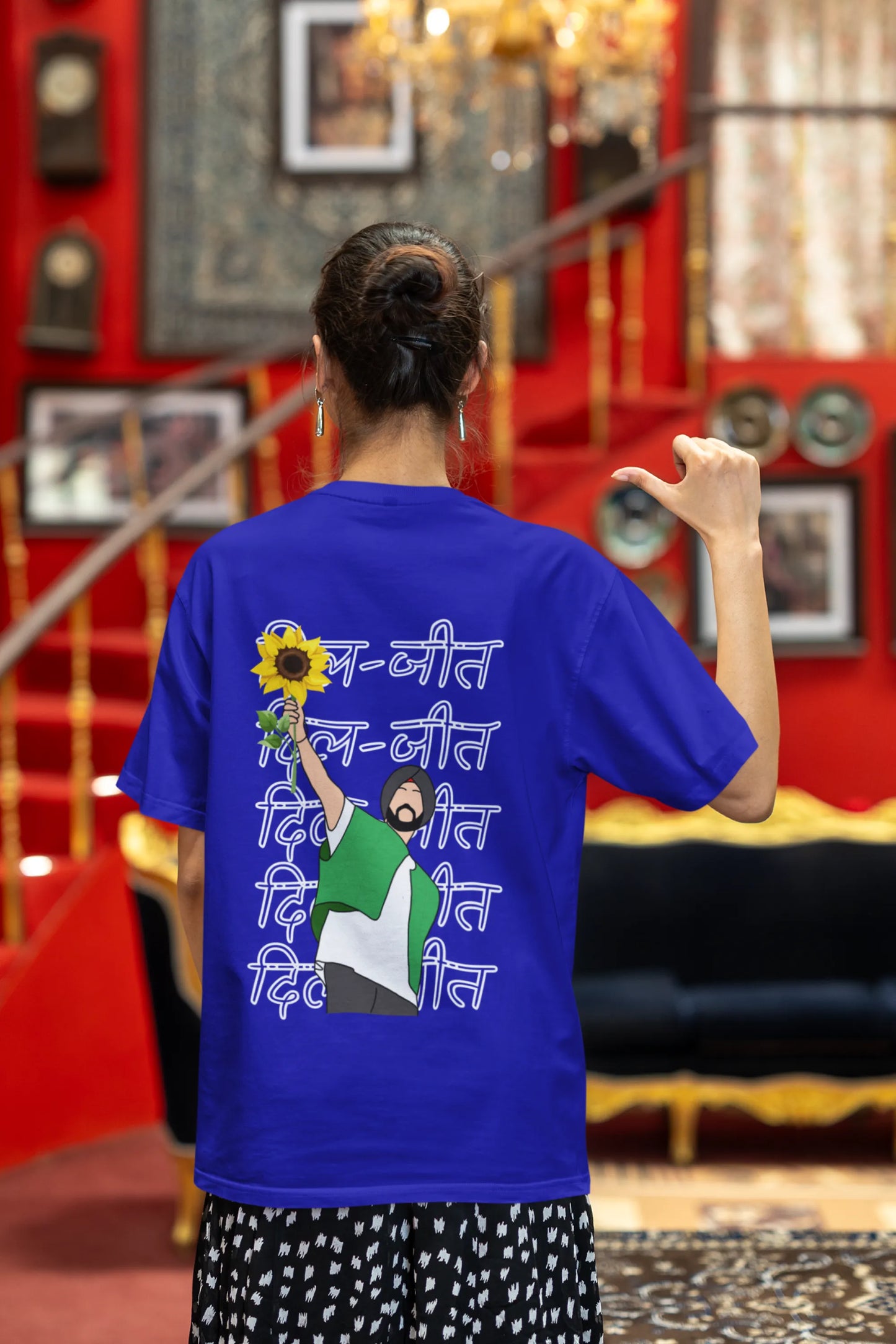 Back view of a female model wearing a royal blue oversized t-shirt with a Diljit Dosanjh portrait with the text "Dil Jeet" in the background.