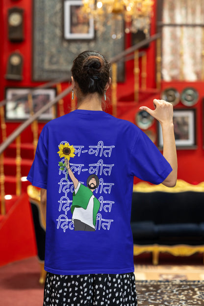 Back view of a female model wearing a royal blue oversized t-shirt with a Diljit Dosanjh portrait with the text "Dil Jeet" in the background.