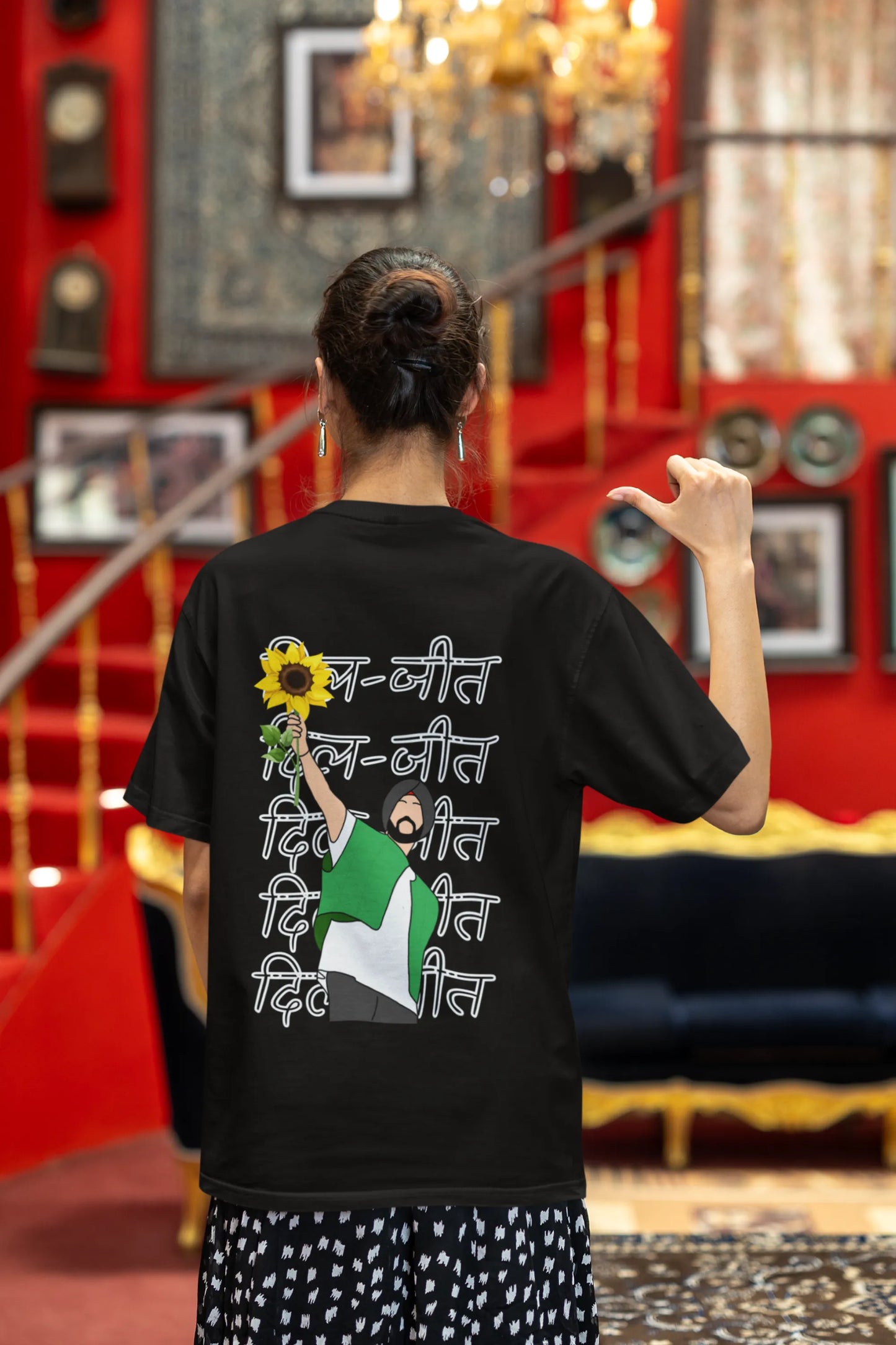 Back view of a female model wearing a black oversized t-shirt with a Diljit Dosanjh portrait with the text "Dil Jeet" in the background.