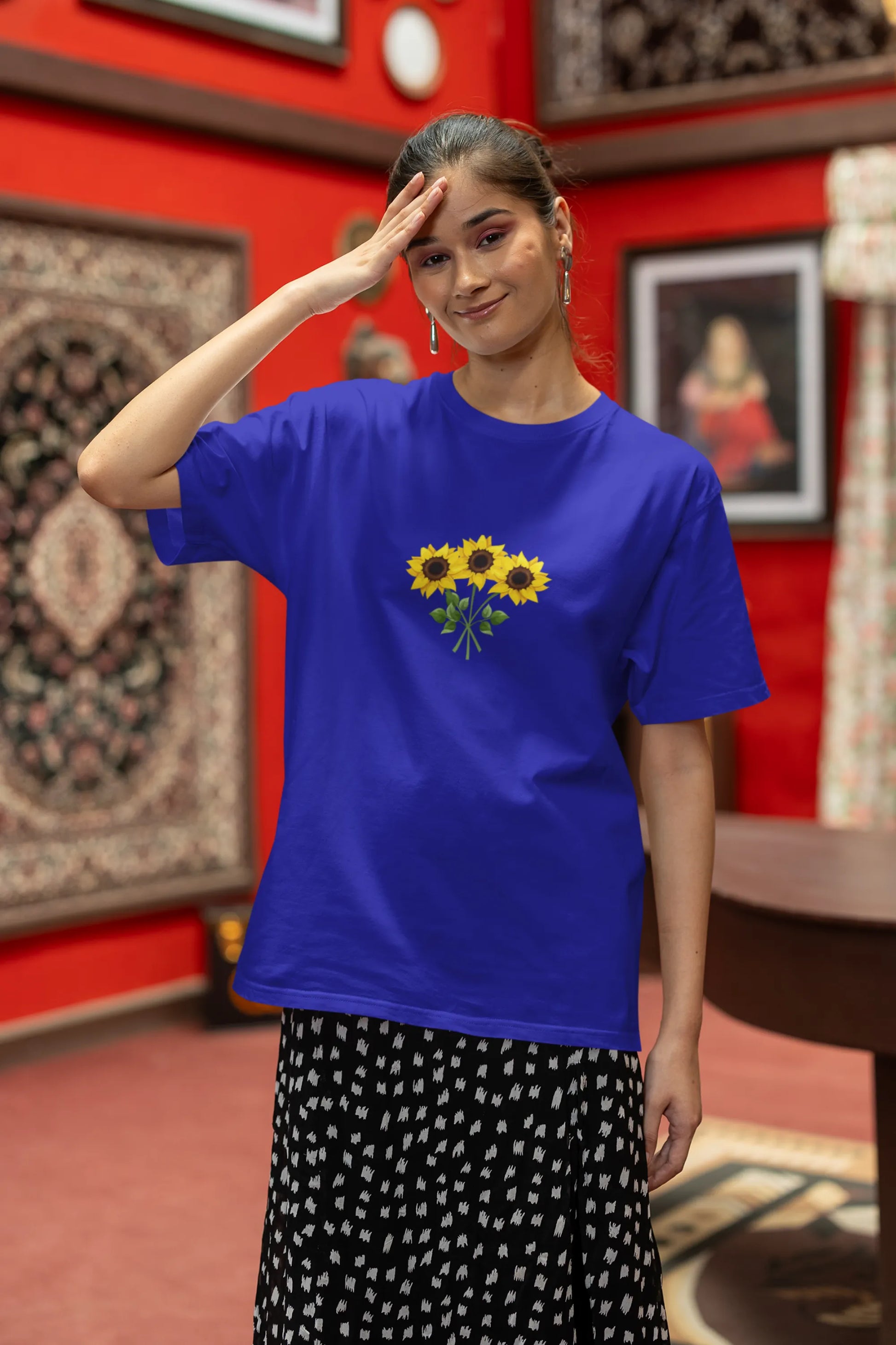 Third front view of a male model wearing a royal blue oversized t-shirt featuring three vibrant sunflowers arranged in a bunch. 
