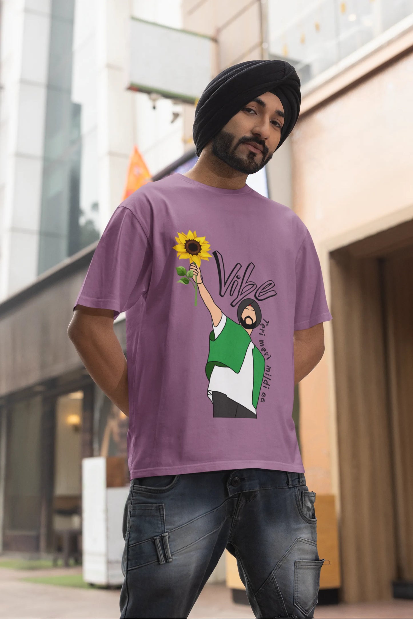 Third front view of male model wearing a dirty purple oversized t shirt with a design of Diljit Dosanjh holding a sunflower, with the text "Vibe Teri Meri".