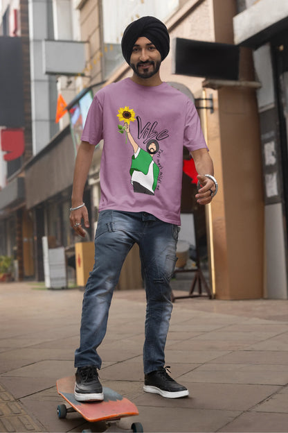 First front view of male model wearing a dirty purple oversized t shirt with a design of Diljit Dosanjh holding a sunflower, with the text "Vibe Teri Meri".