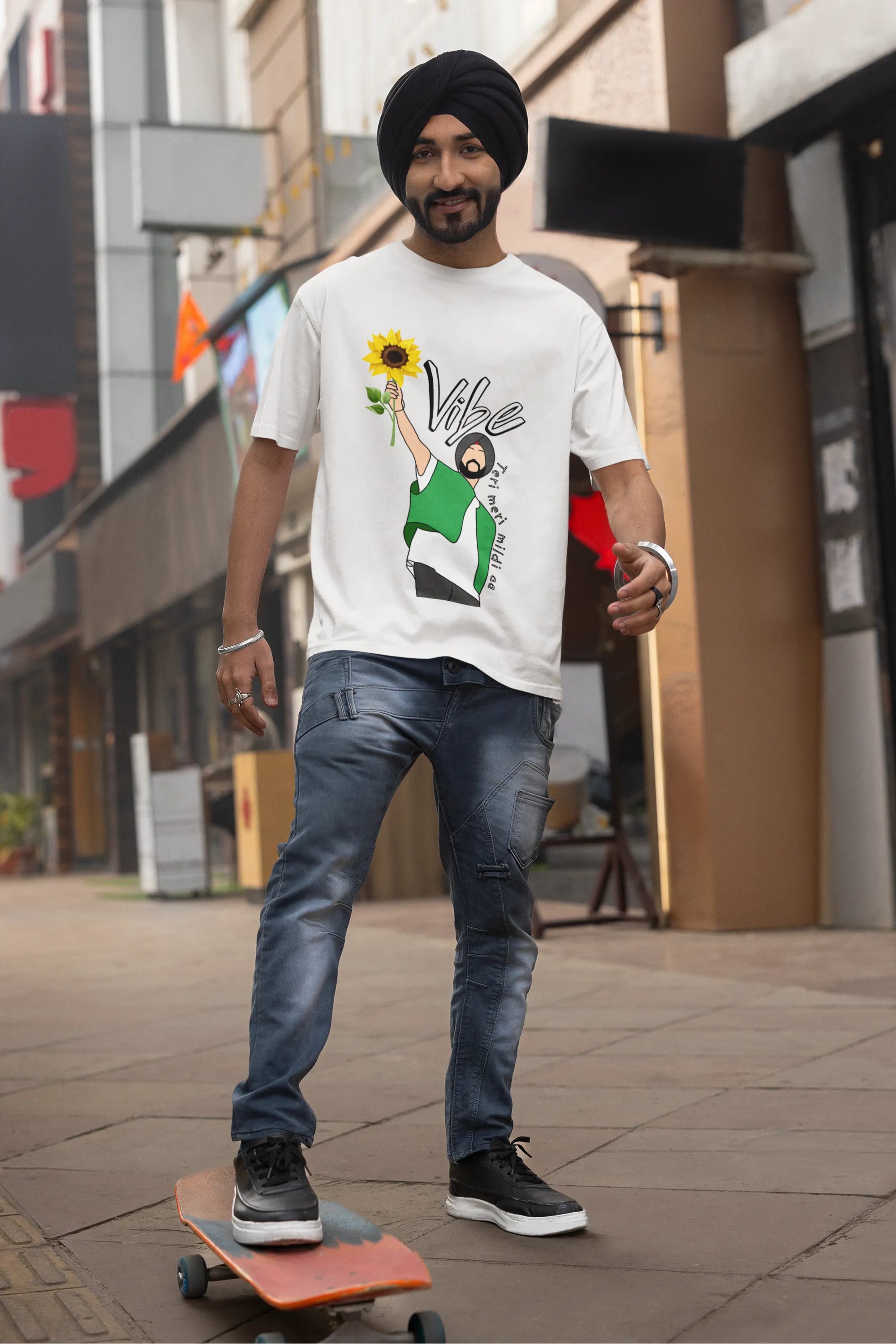 First front view of male model wearing a off-white oversized t shirt with a design of Diljit Dosanjh holding a sunflower, with the text "Vibe Teri Meri".