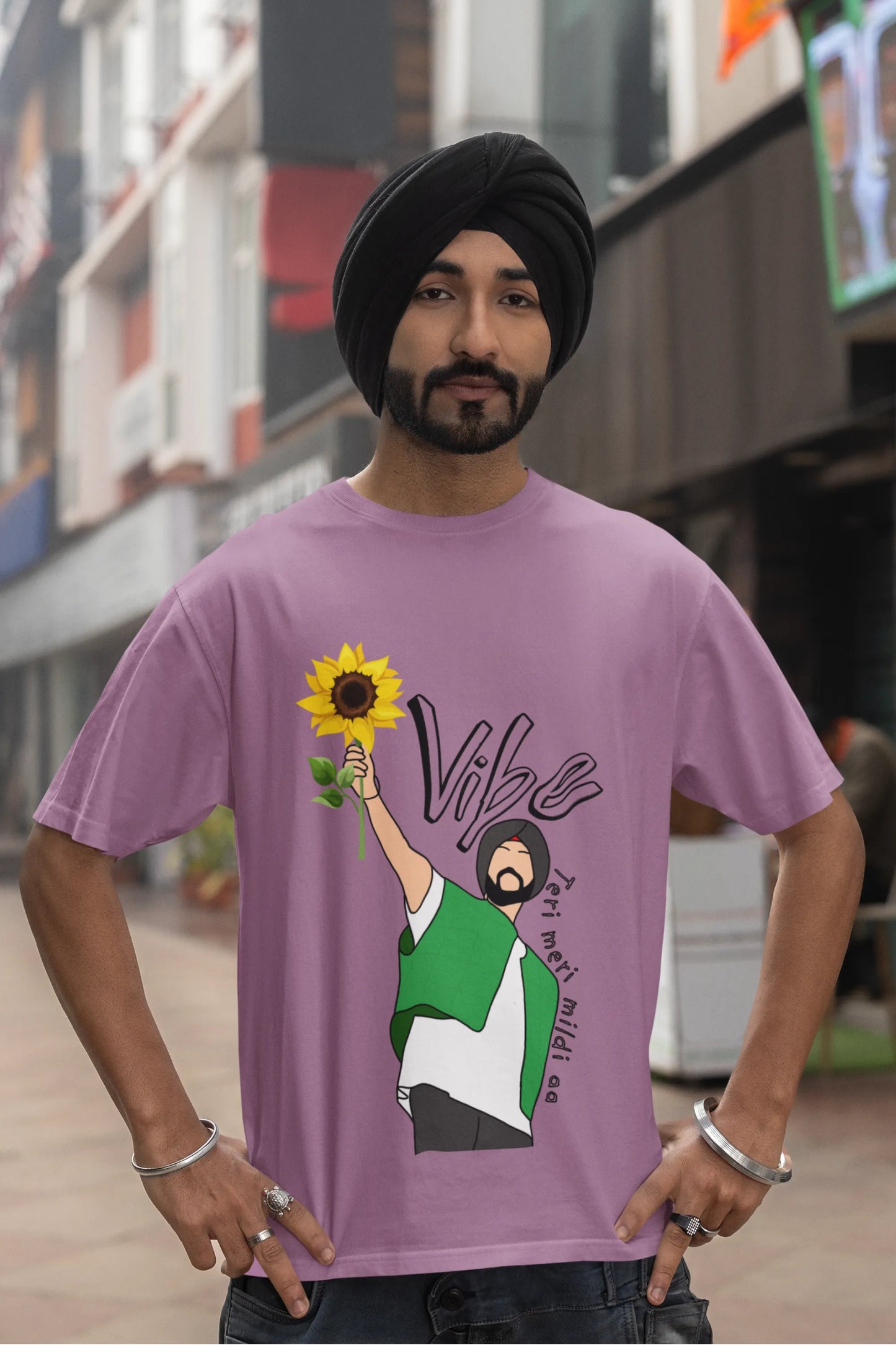 Fourth front view of male model wearing a dirty purple oversized t shirt with a design of Diljit Dosanjh holding a sunflower, with the text "Vibe Teri Meri".
