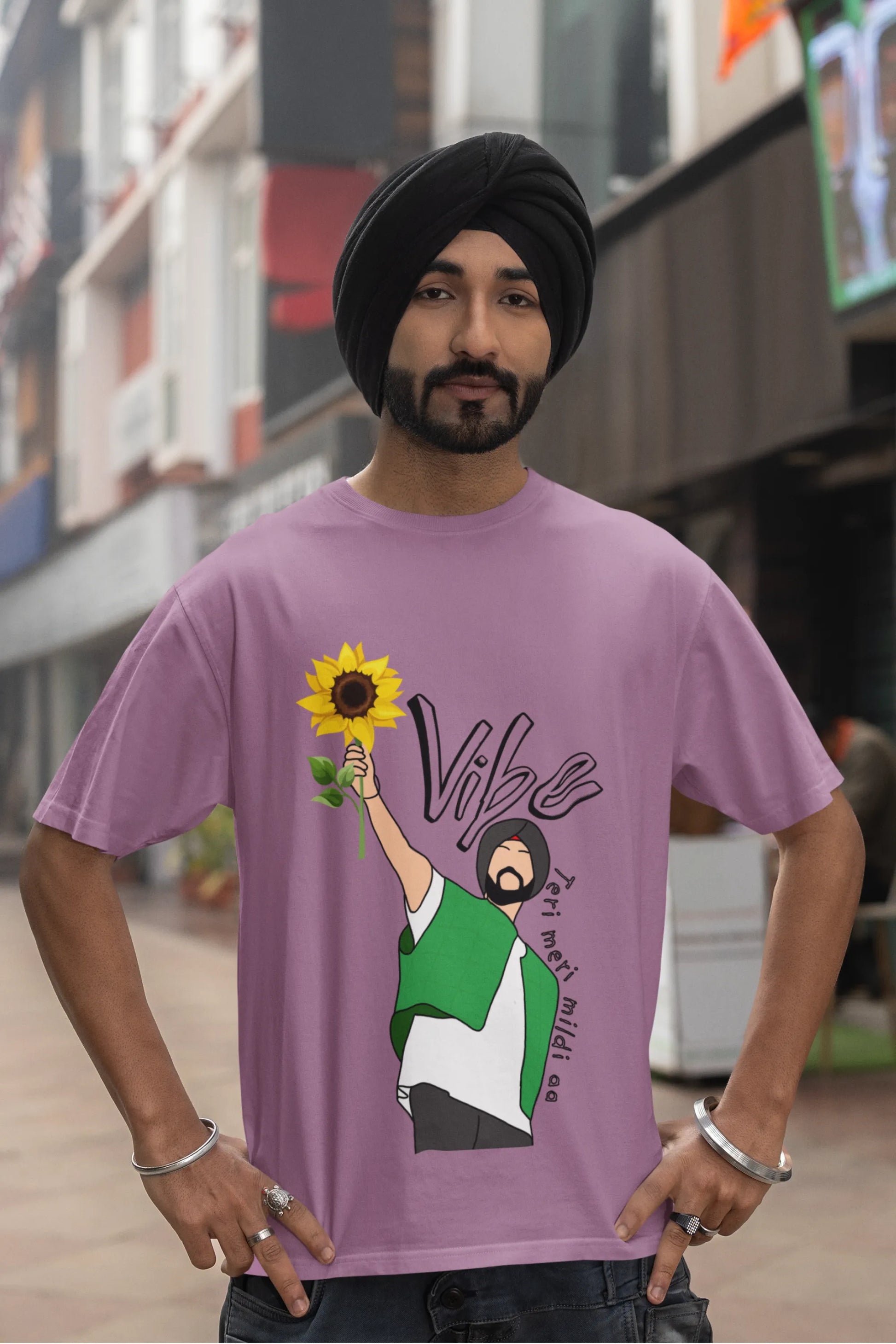 Fourth front view of male model wearing a dirty purple oversized t shirt with a design of Diljit Dosanjh holding a sunflower, with the text "Vibe Teri Meri".