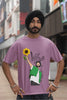 Fourth front view of male model wearing a dirty purple oversized t shirt with a design of Diljit Dosanjh holding a sunflower, with the text 