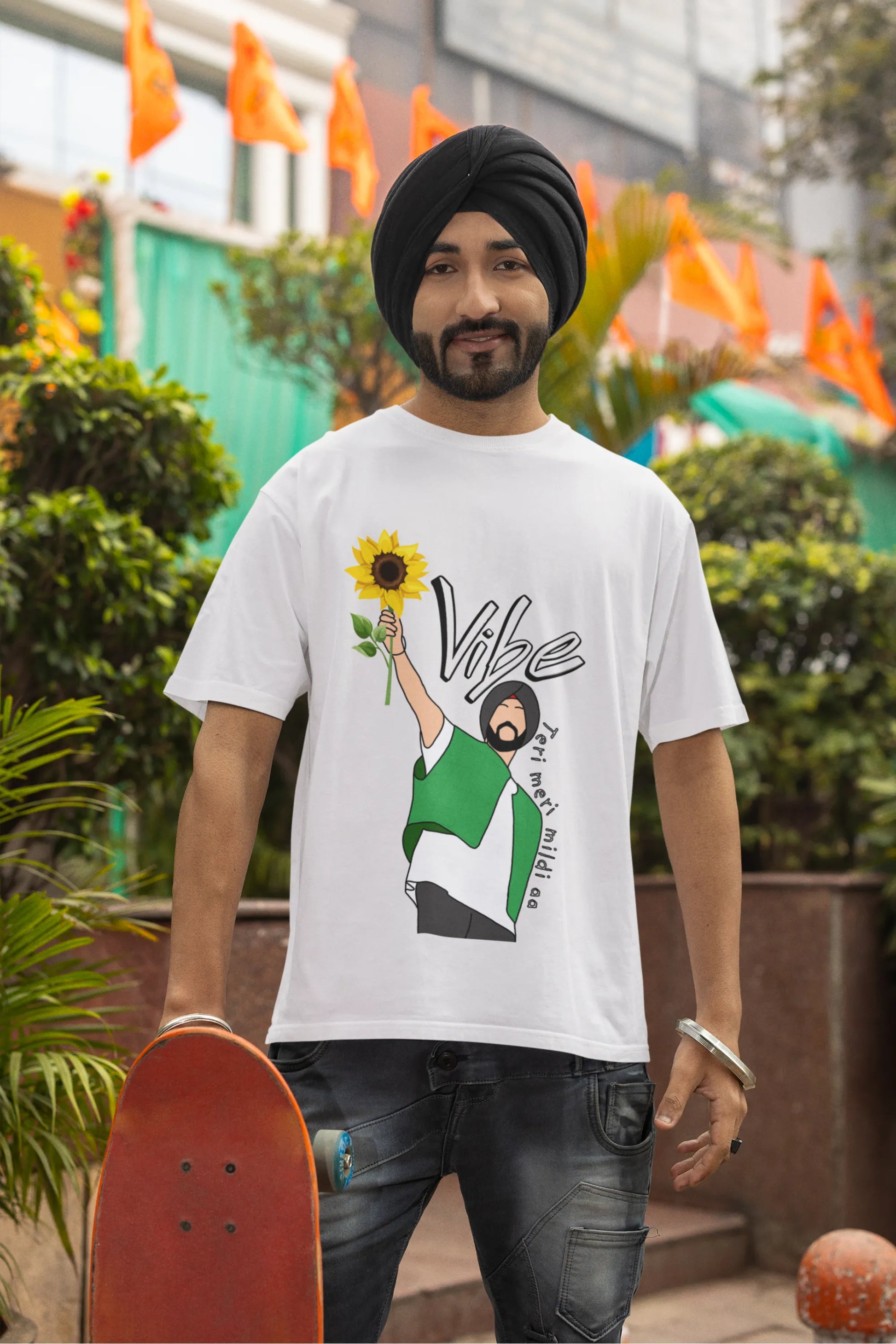 Second front view of male model wearing a off-white oversized t shirt with a design of Diljit Dosanjh holding a sunflower, with the text "Vibe Teri Meri".