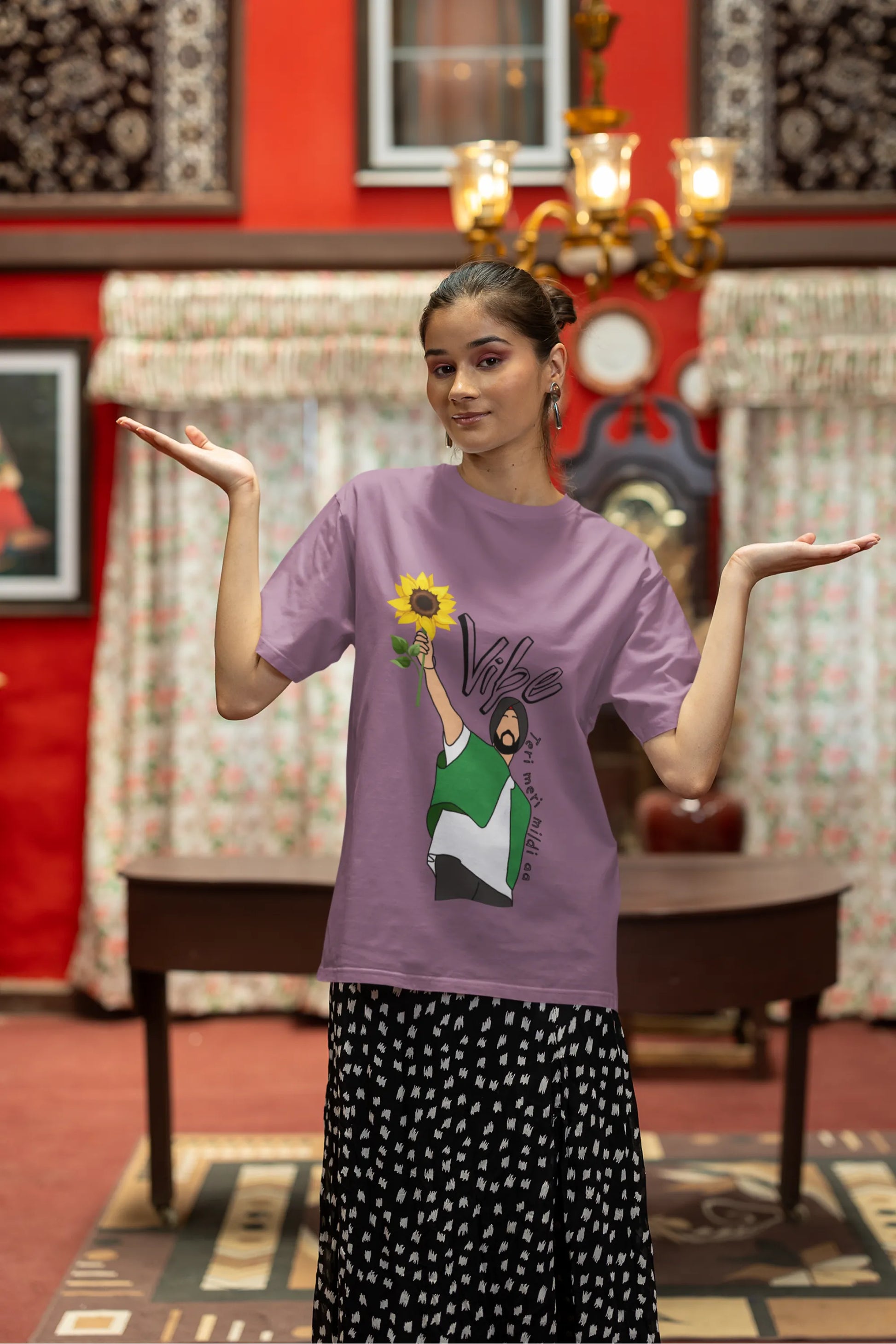Third front view of female model wearing a dirty purple oversized t shirt with a design of Diljit Dosanjh holding a sunflower, with the text "Vibe Teri Meri".