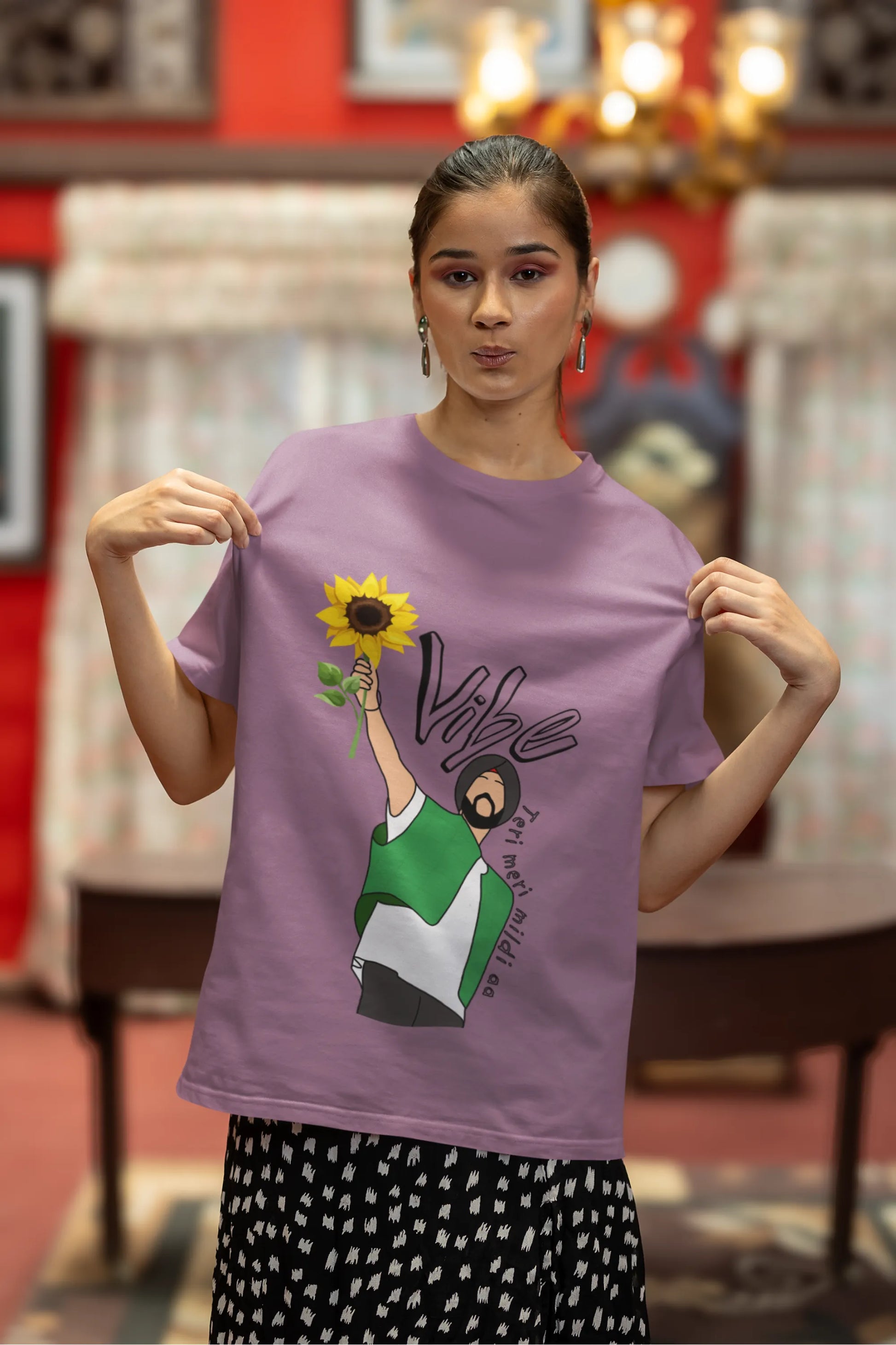 Second front view of female model wearing a dirty purple oversized t shirt with a design of Diljit Dosanjh holding a sunflower, with the text "Vibe Teri Meri".