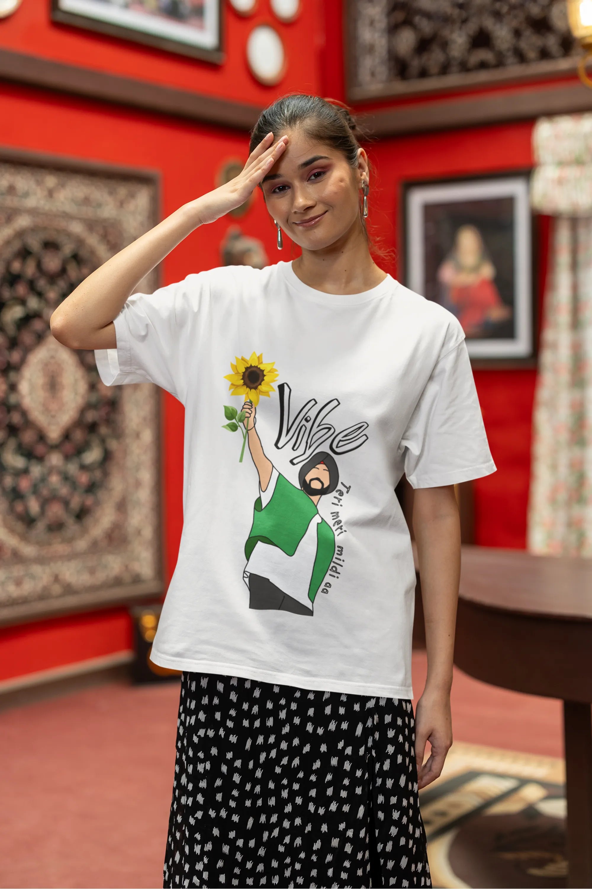 First front view of female model wearing a off-white oversized t shirt with a design of Diljit Dosanjh holding a sunflower, with the text "Vibe Teri Meri".