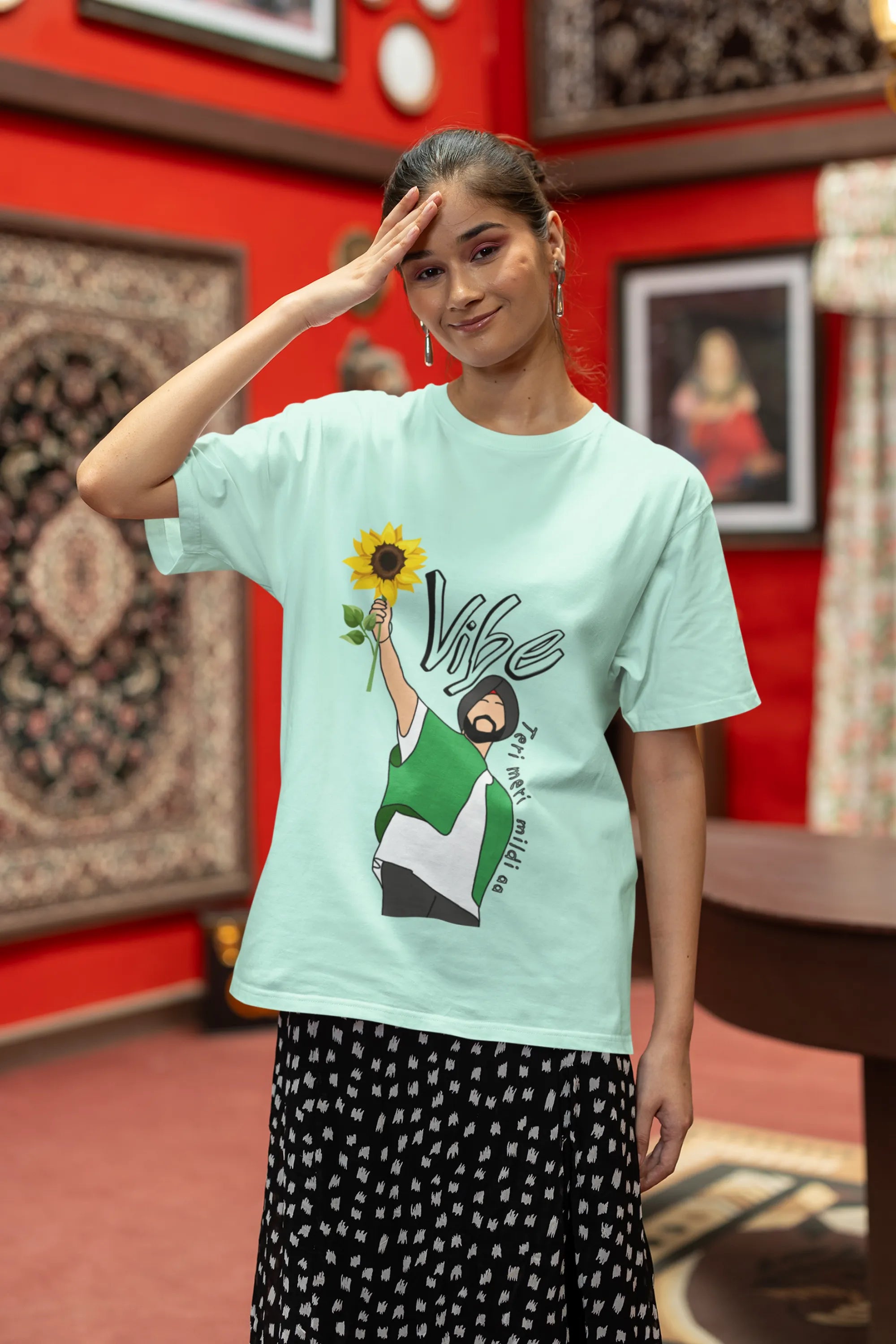 First front view of female model wearing a mint green oversized t shirt with a design of Diljit Dosanjh holding a sunflower, with the text "Vibe Teri Meri".