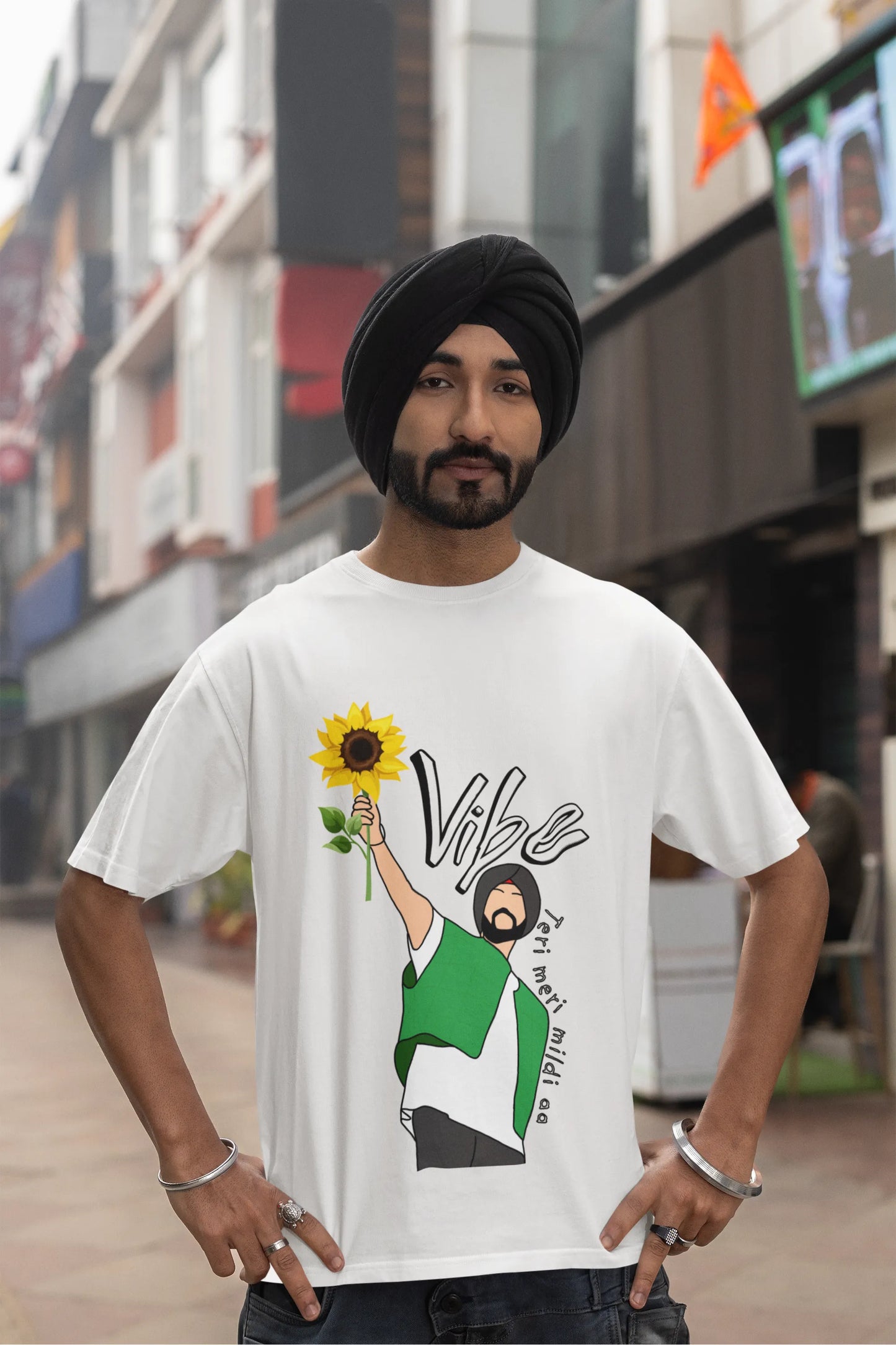 Fourth front view of male model wearing a off-white oversized t shirt with a design of Diljit Dosanjh holding a sunflower, with the text "Vibe Teri Meri".