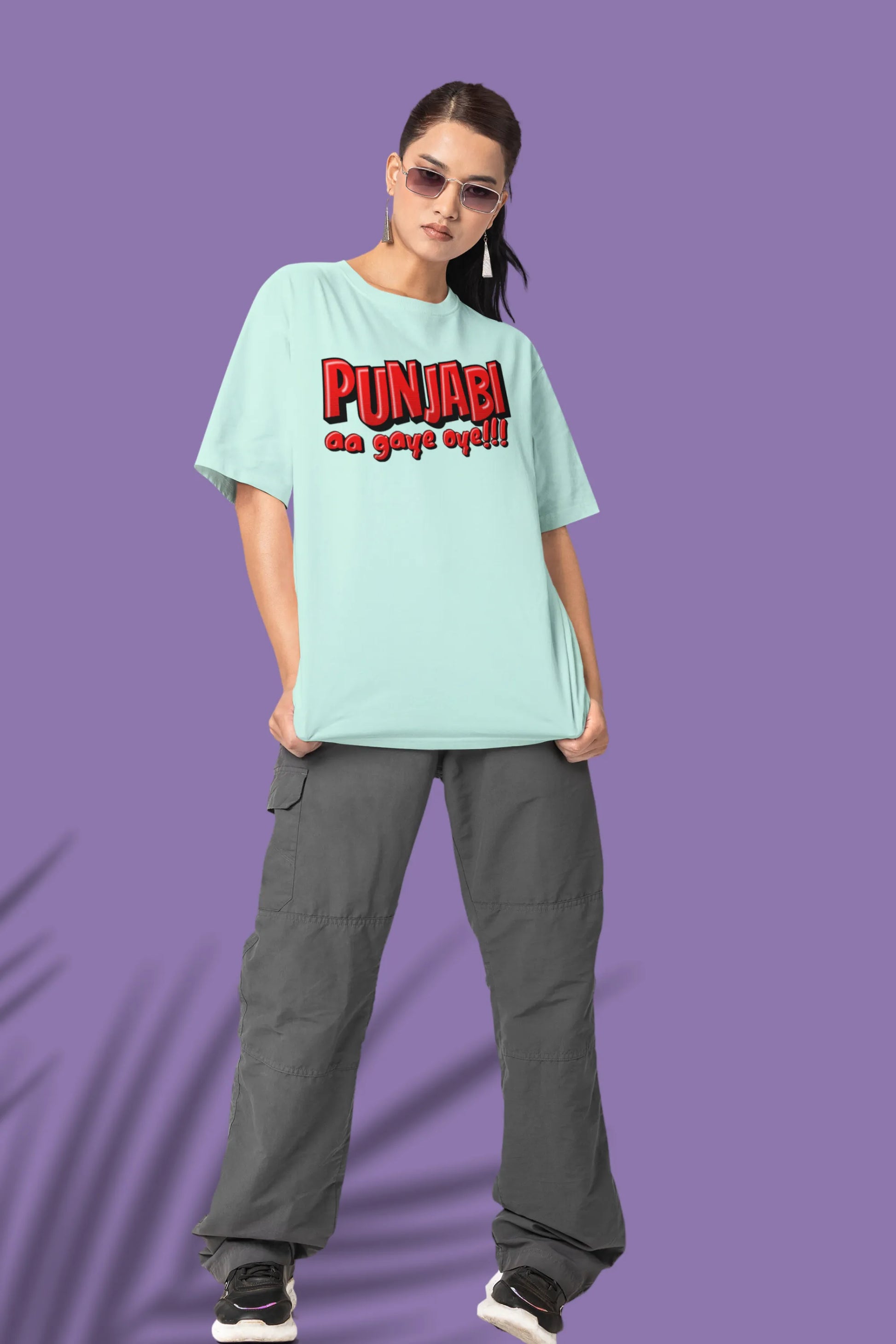 Fourth front view of a female model wearing an mint-green oversized t-shirt with the text "Punjabi Aa Gaye Oye".