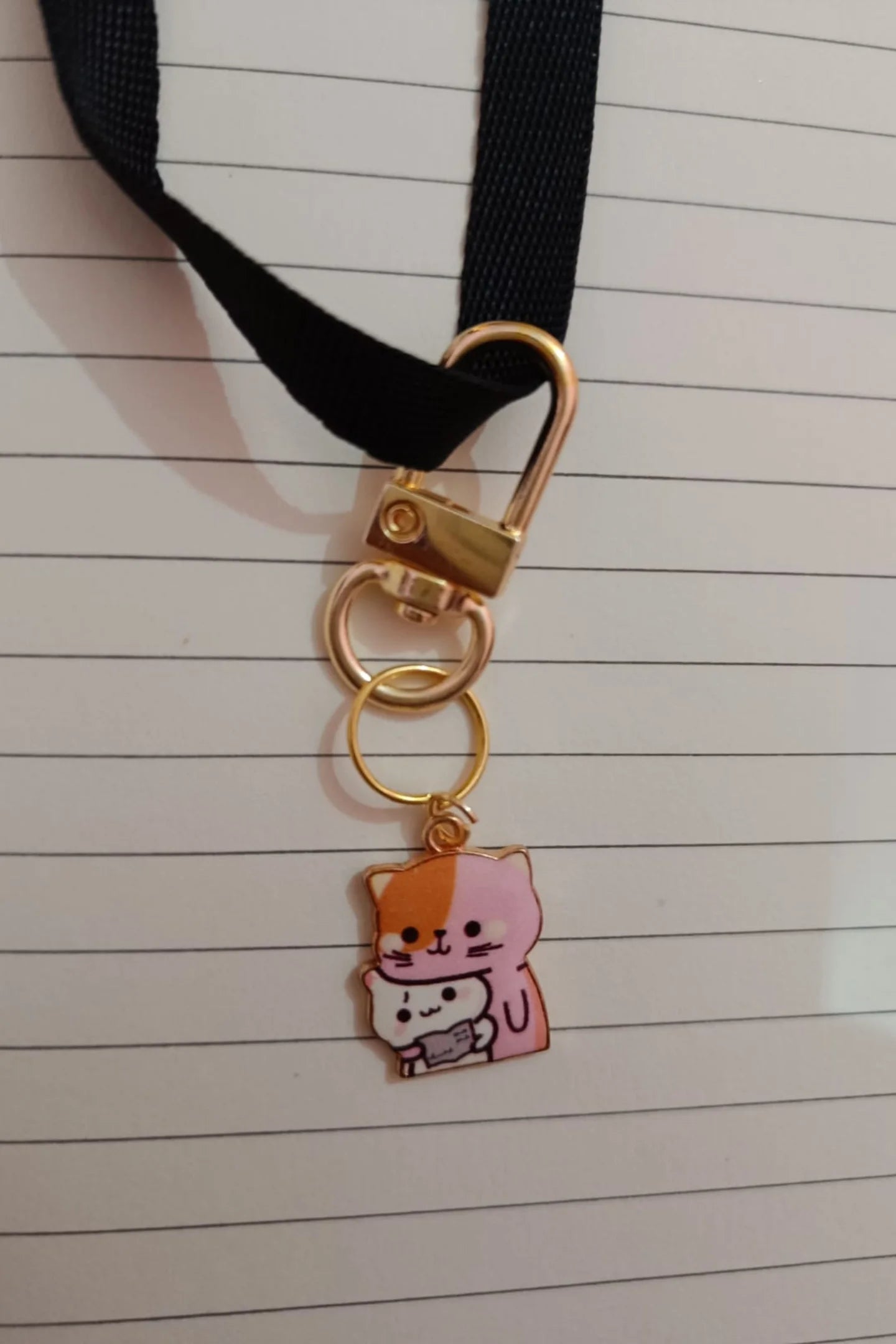 First view of a keychain featuring a design of a mother cat and her kitten.