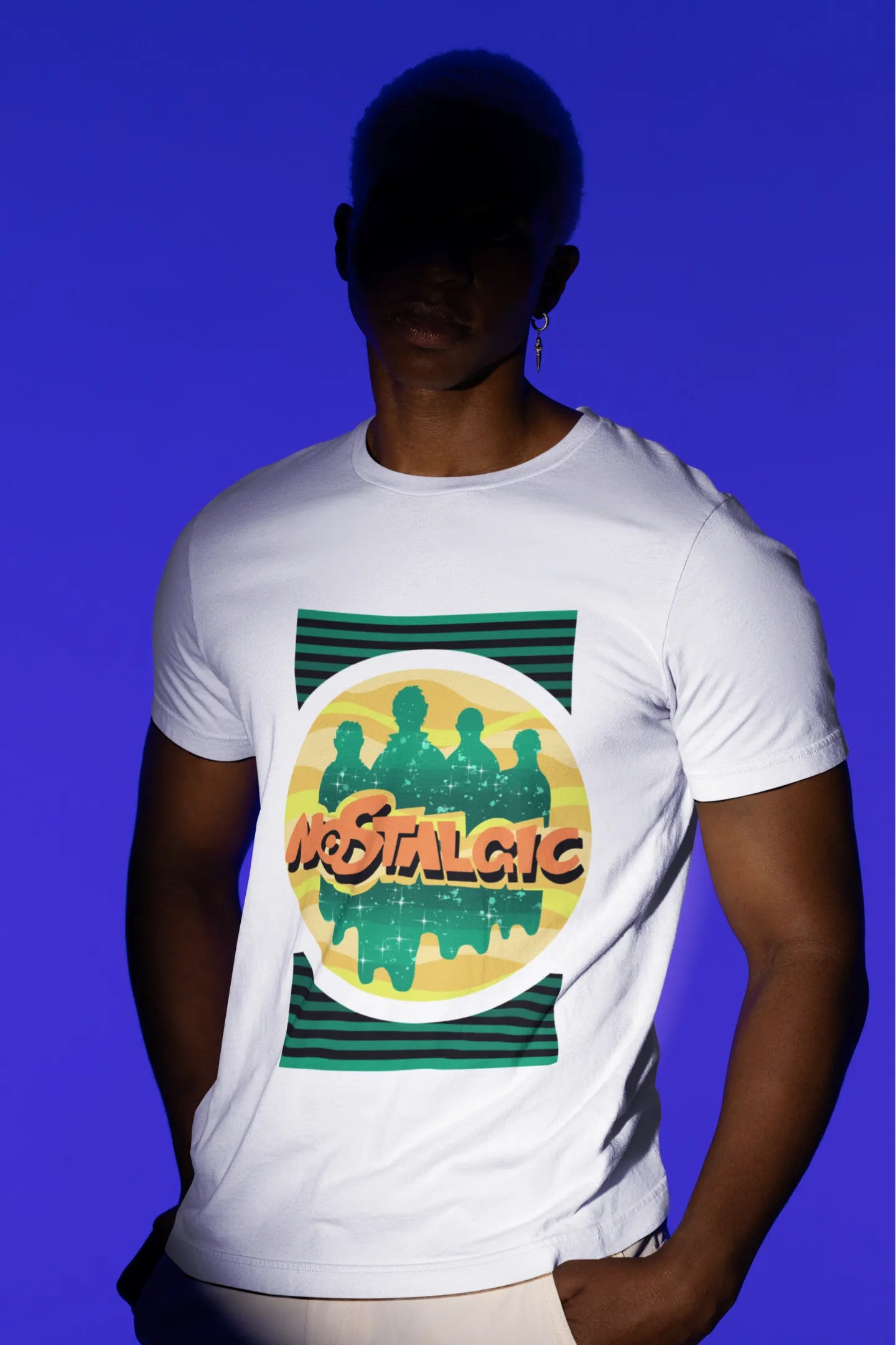 Second view of a male model wearing an oversized off-white t-shirt with a shadow silhouette of the Coldplay band members and the word "Nostalgic" printed on it.