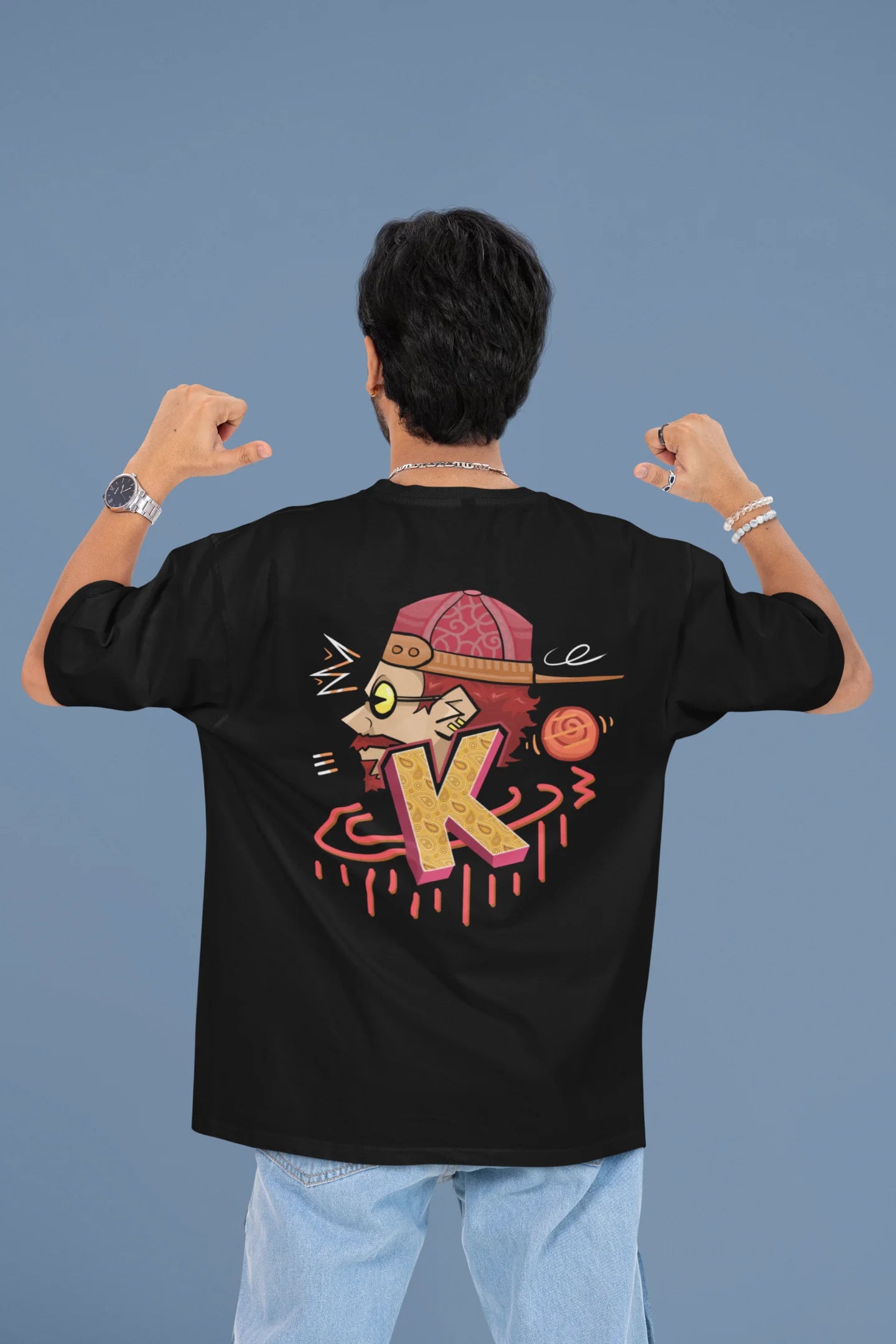 Back view of a male model wearing a black oversized t-shirt featuring the Hindi word for "cool" with a unique, playful design.