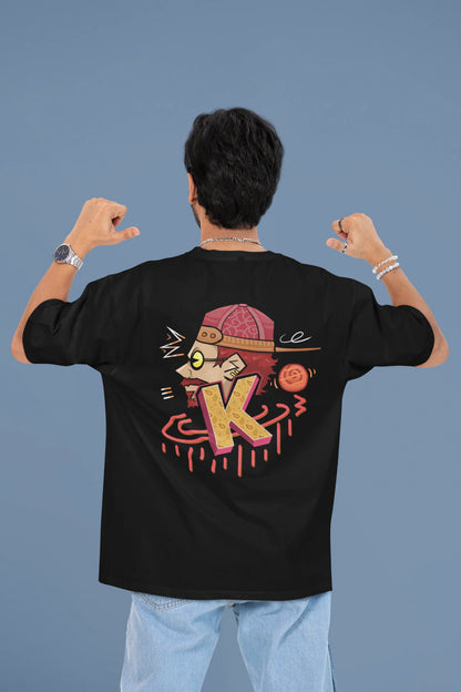 Back view of a male model wearing a black oversized t-shirt featuring the Hindi word for "cool" with a unique, playful design.