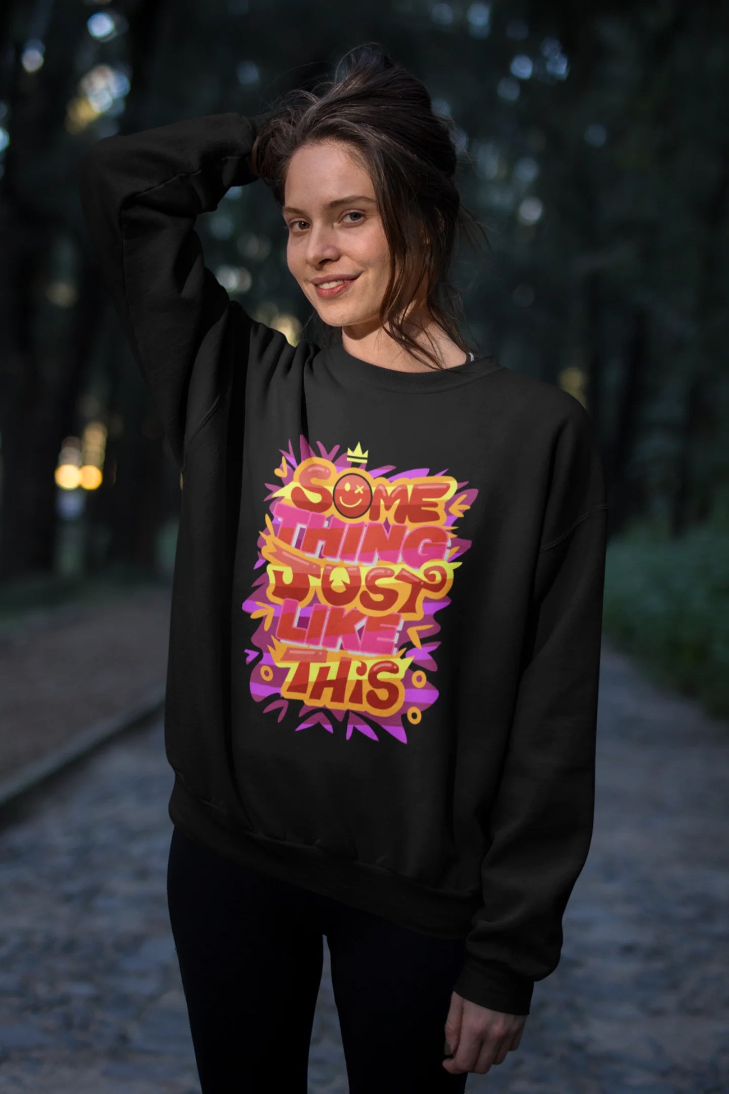 Third front view of a female model wearing an black sweatshirt featuring the designs inspired from Coldplay's "Something Just Like This" music video.