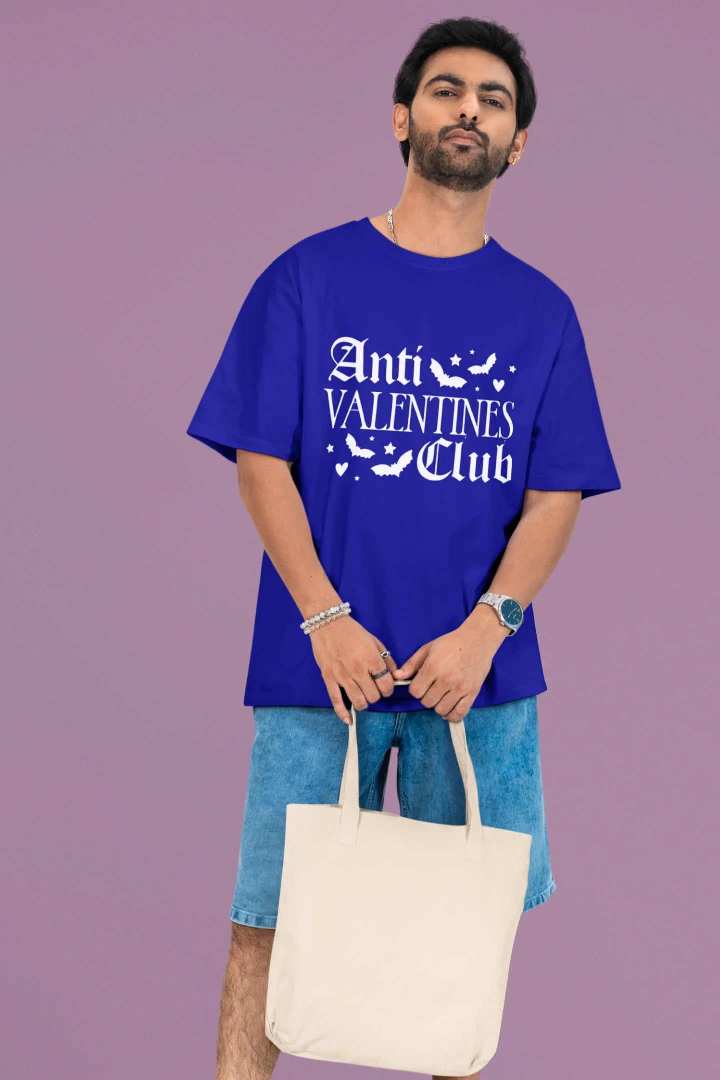 First front view of a male model wearing a royal blue oversized t-shirt with the text "Anti-Valentine's Club" printed on it.