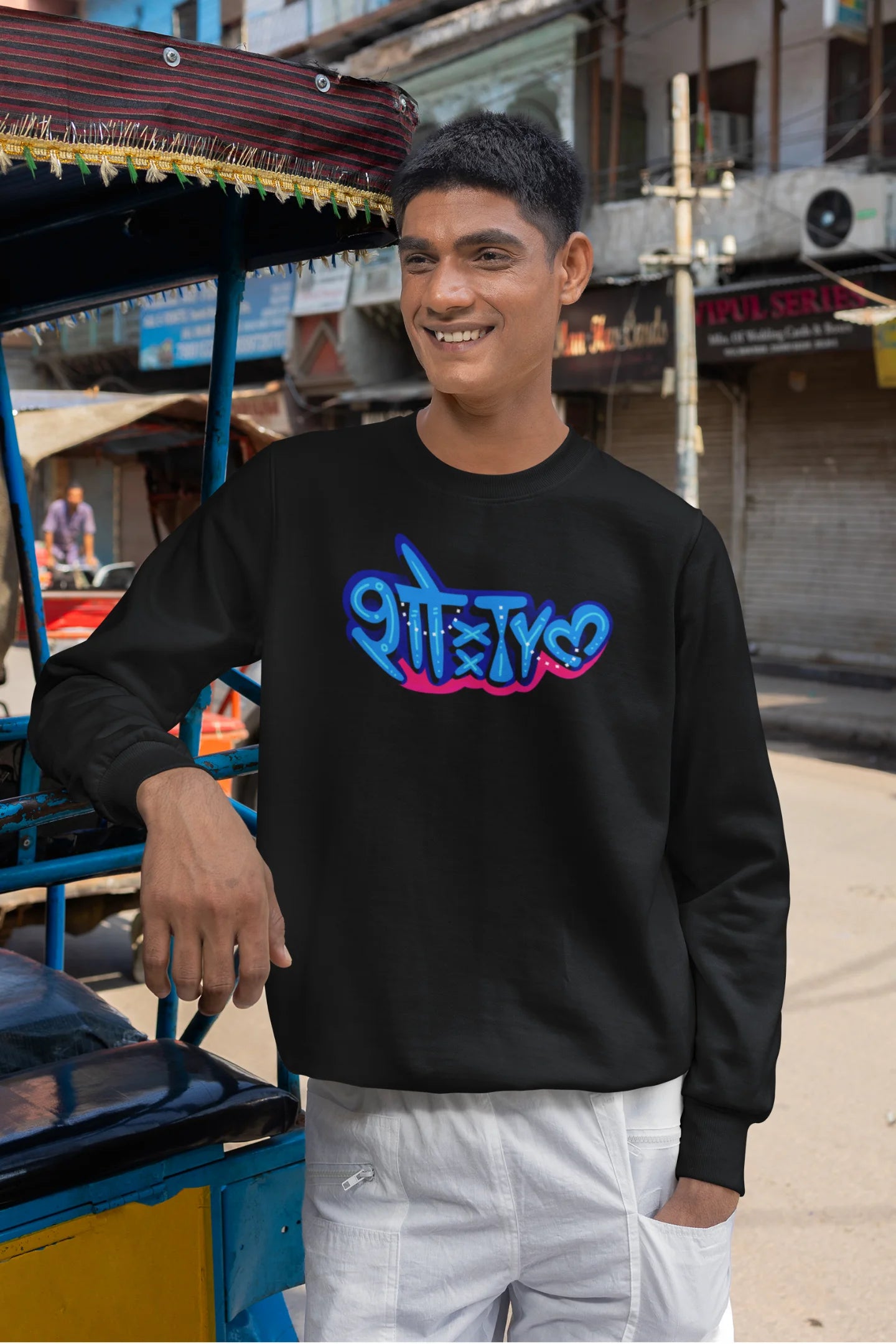 4th front view of a male model wearing a black oversized t-shirt featuring "Showtime" in Hindi.