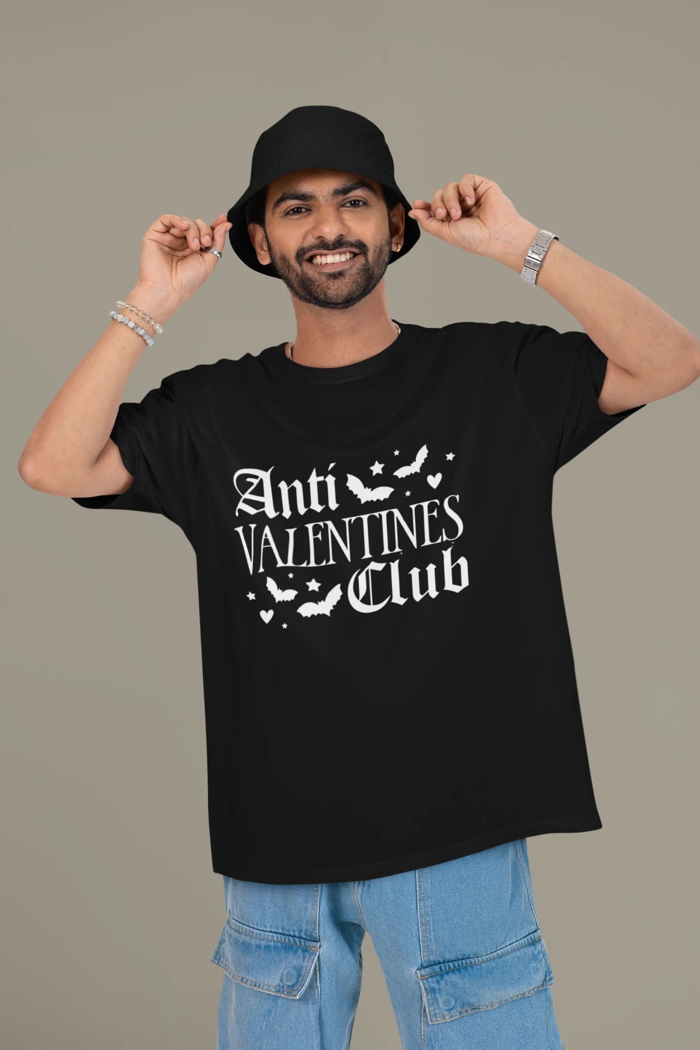 2nd front view of a male model wearing a black oversized t-shirt with the text "Anti-Valentine's Club" printed on it.