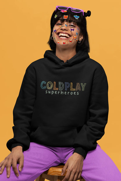 3rd front view of a female model wearing an black hoodie with a design inspired by the "Something Just Like This" music video, featuring the word "Superheroes".