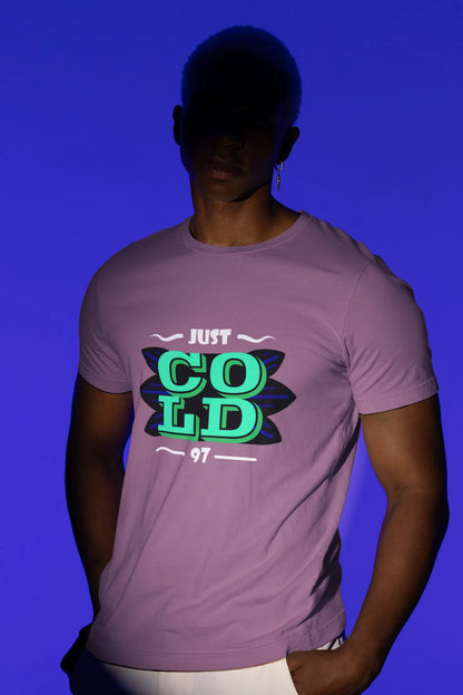 First front view of a male model wearing an dirty purple oversized t-shirt with the text "Just Cold" printed on it.