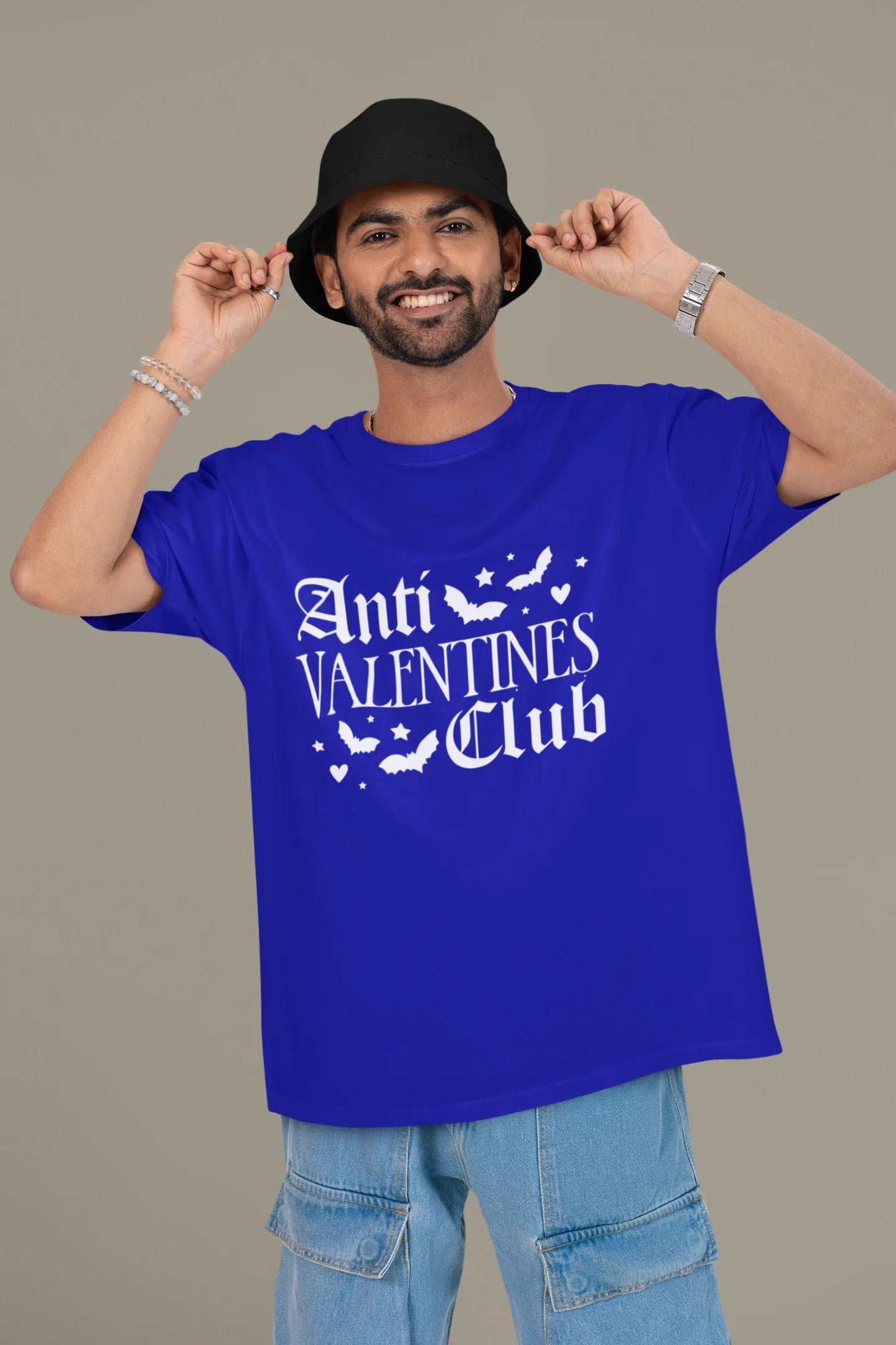 2nd front view of a male model wearing a royal blue oversized t-shirt with the text "Anti-Valentine's Club" printed on it.