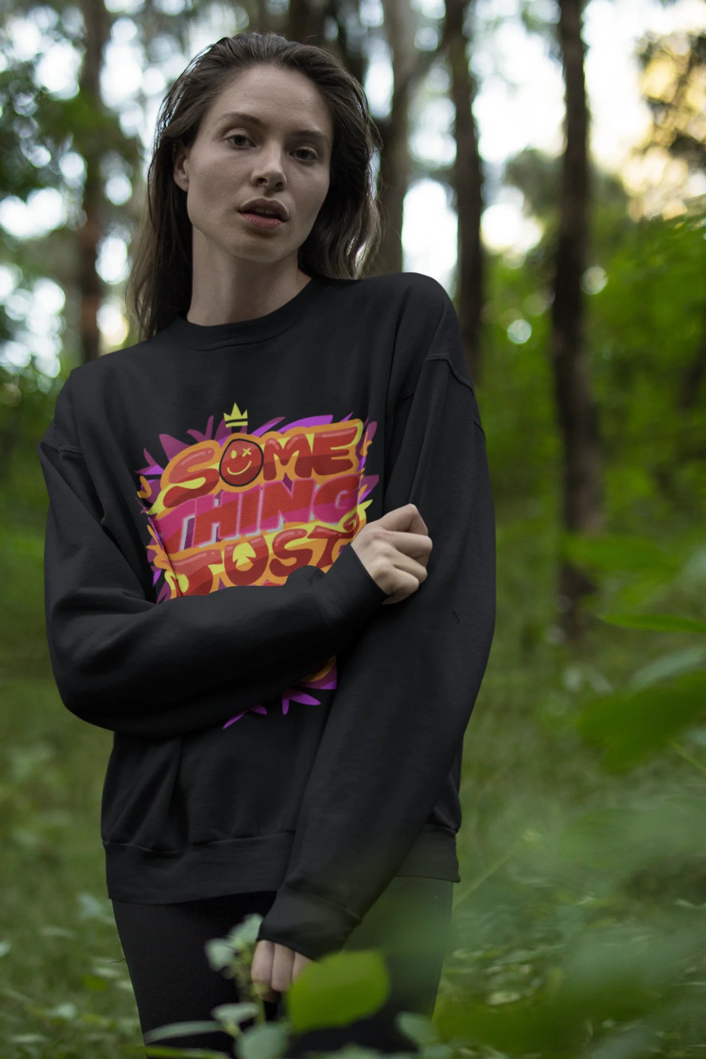 Fourth front view of a female model wearing an black sweatshirt featuring the designs inspired from Coldplay's "Something Just Like This" music video.